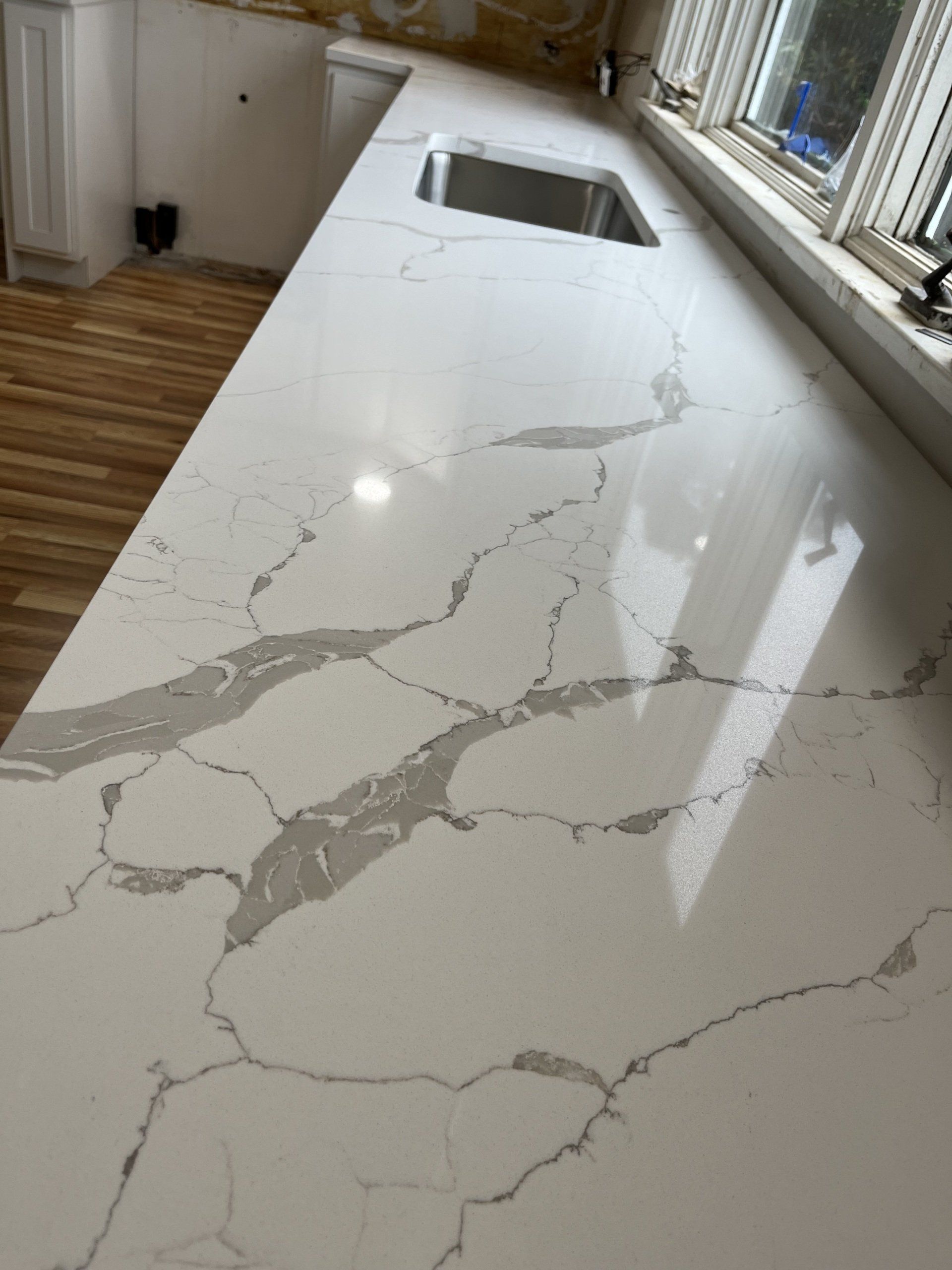 A quartz kitchen countertop with a sink and a window