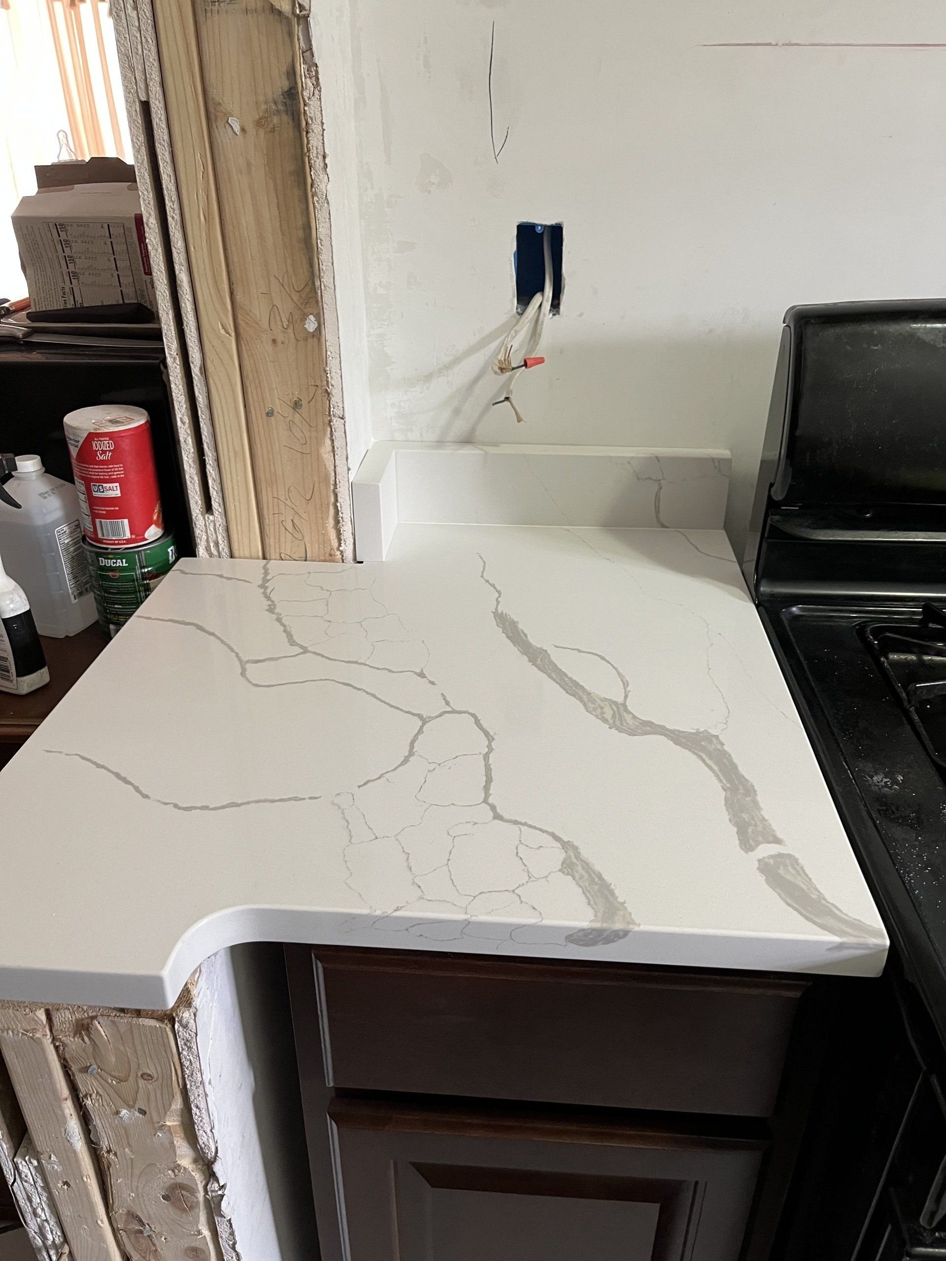 A kitchen with a white countertop and a black stove top oven