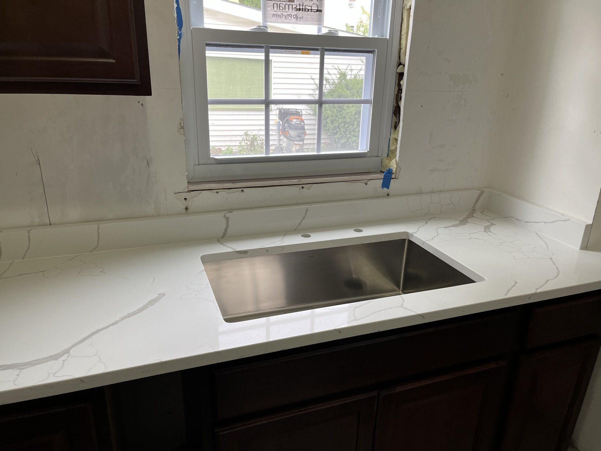 Stainless steel sink on a white quartz countertop