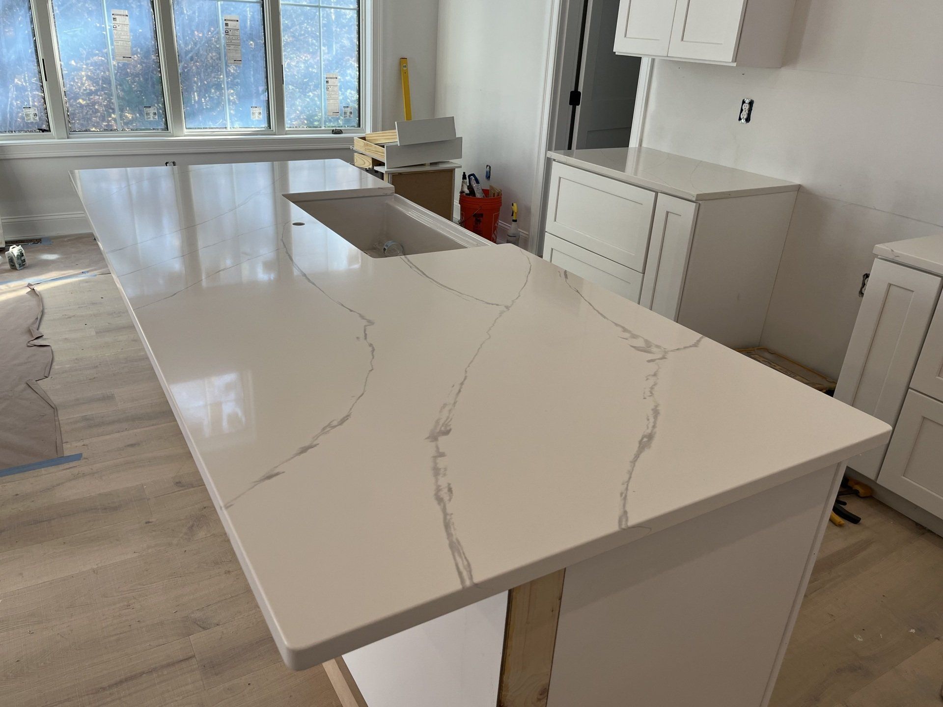 A kitchen with a large white counter top and a sink