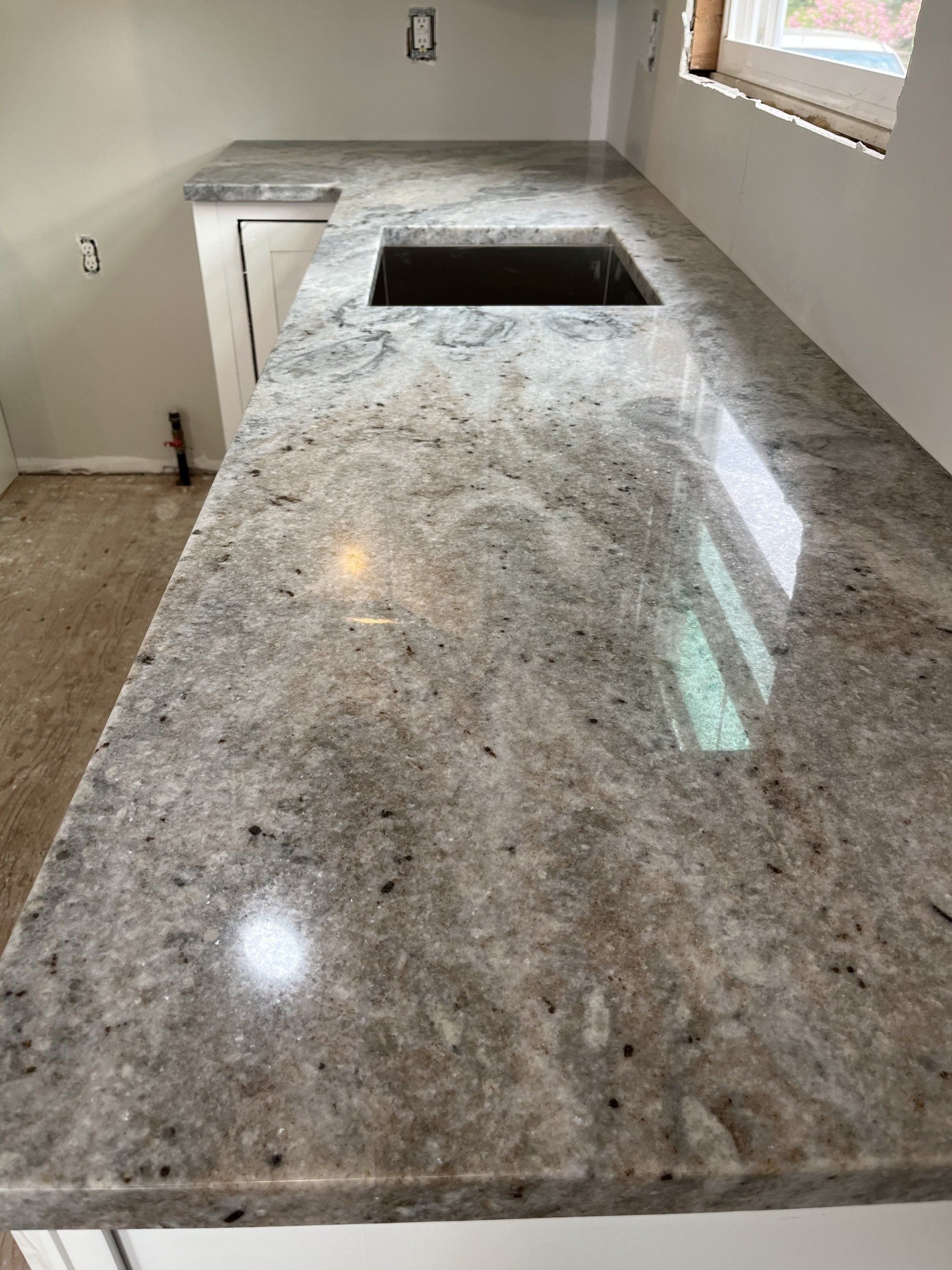 A kitchen with a granite counter top and a sink