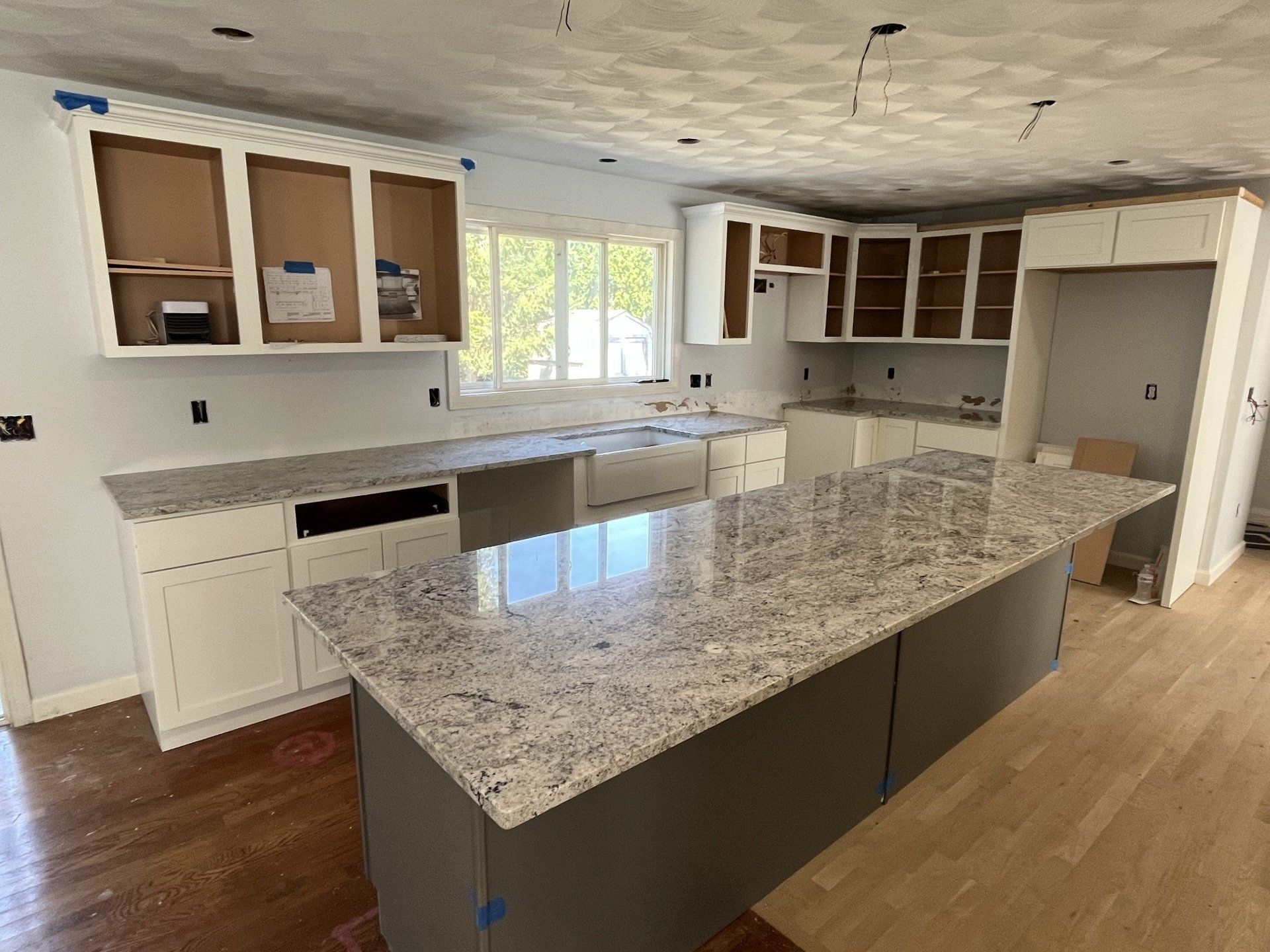 A kitchen with granite countertops and white cabinets 