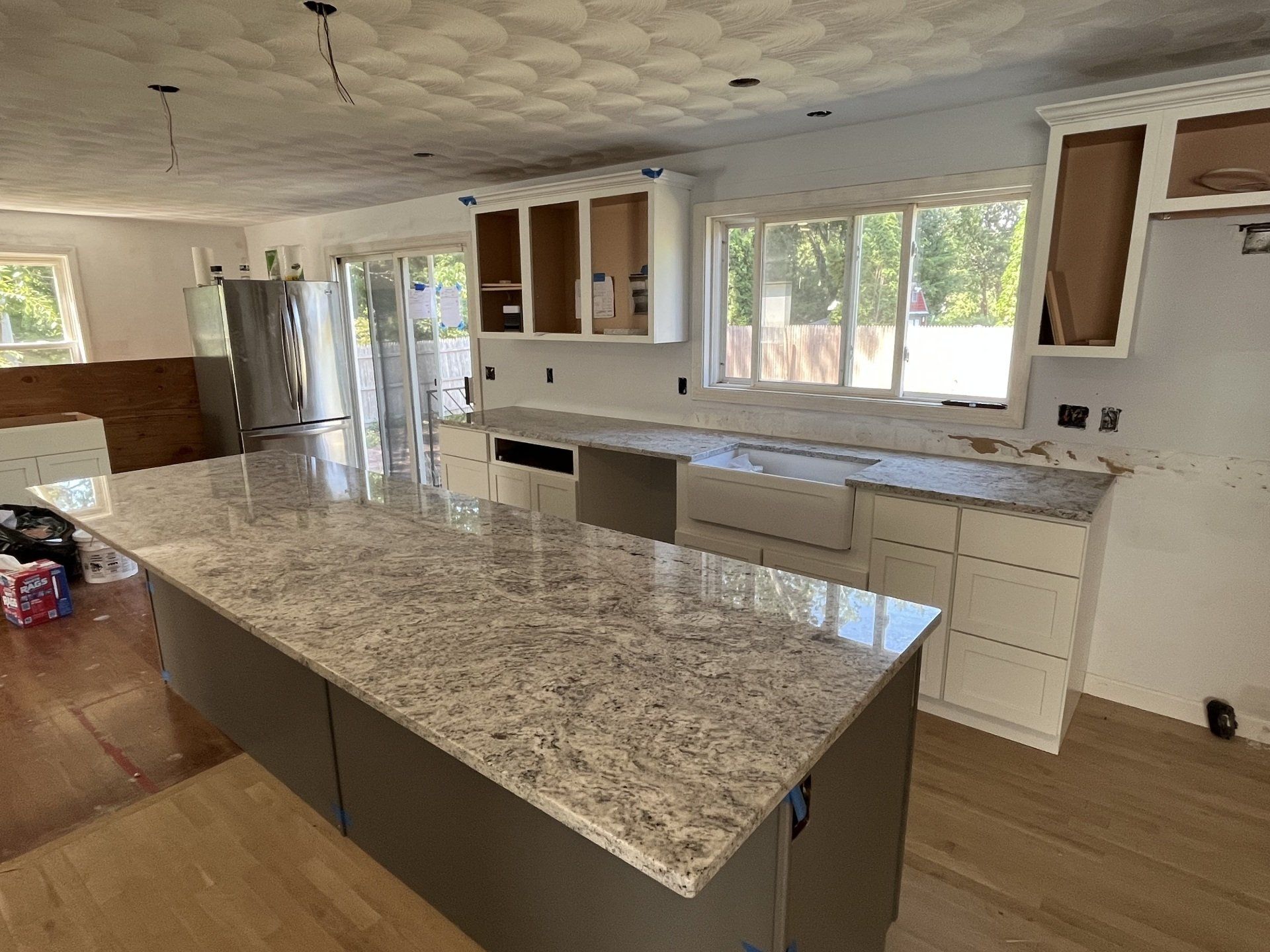 A kitchen with granite counter tops and white cabinets