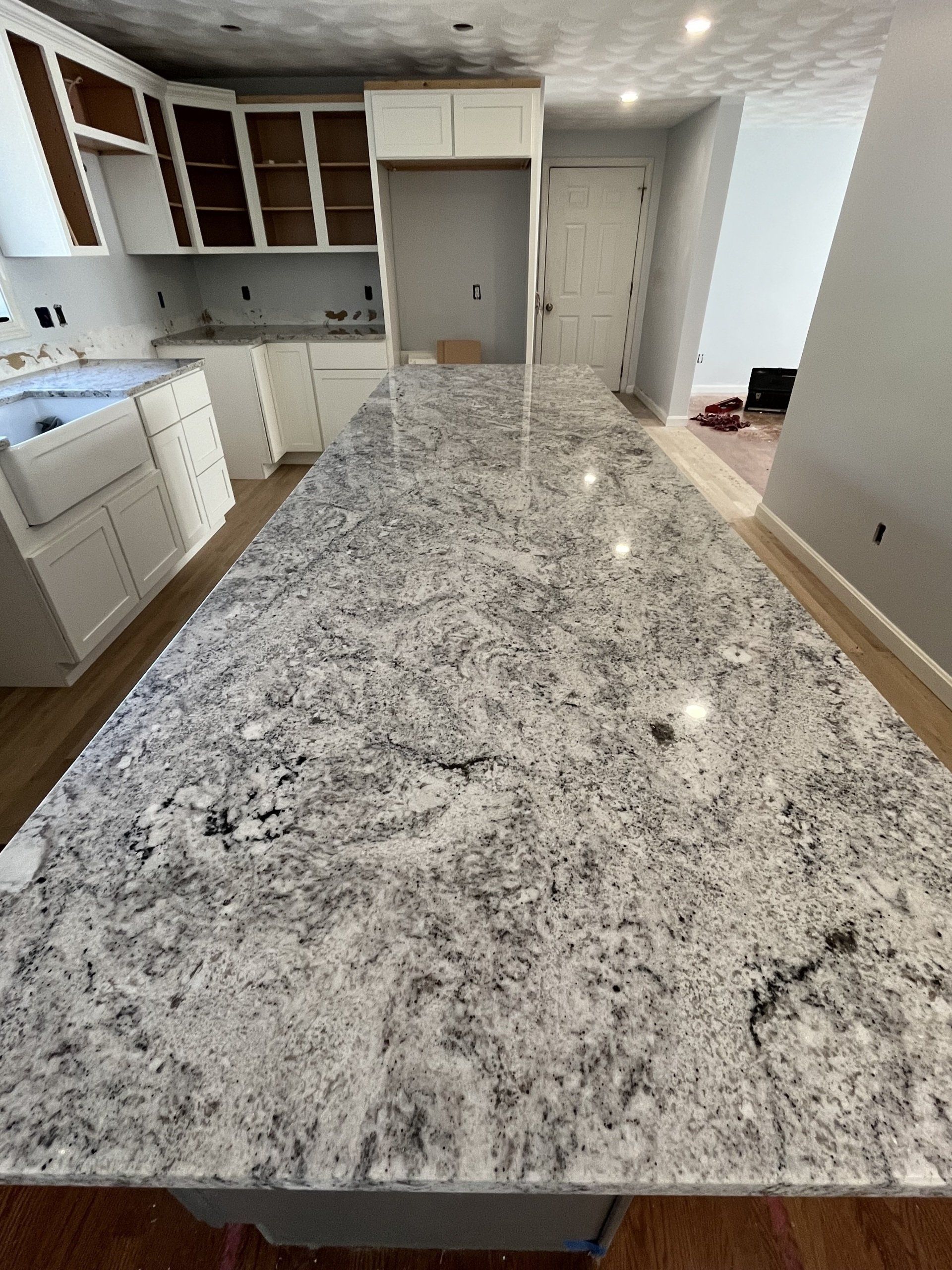 Large granite countertop and white cabinets