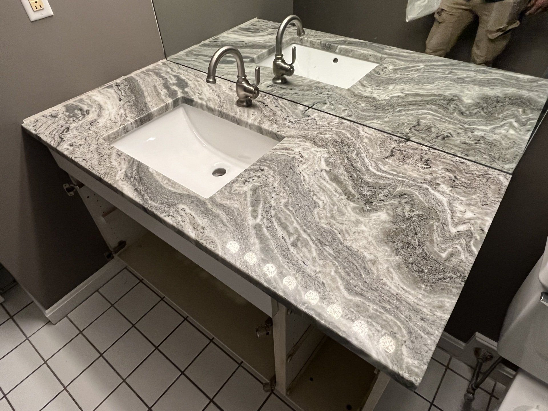 A bathroom with a sink, mirror, and toilet