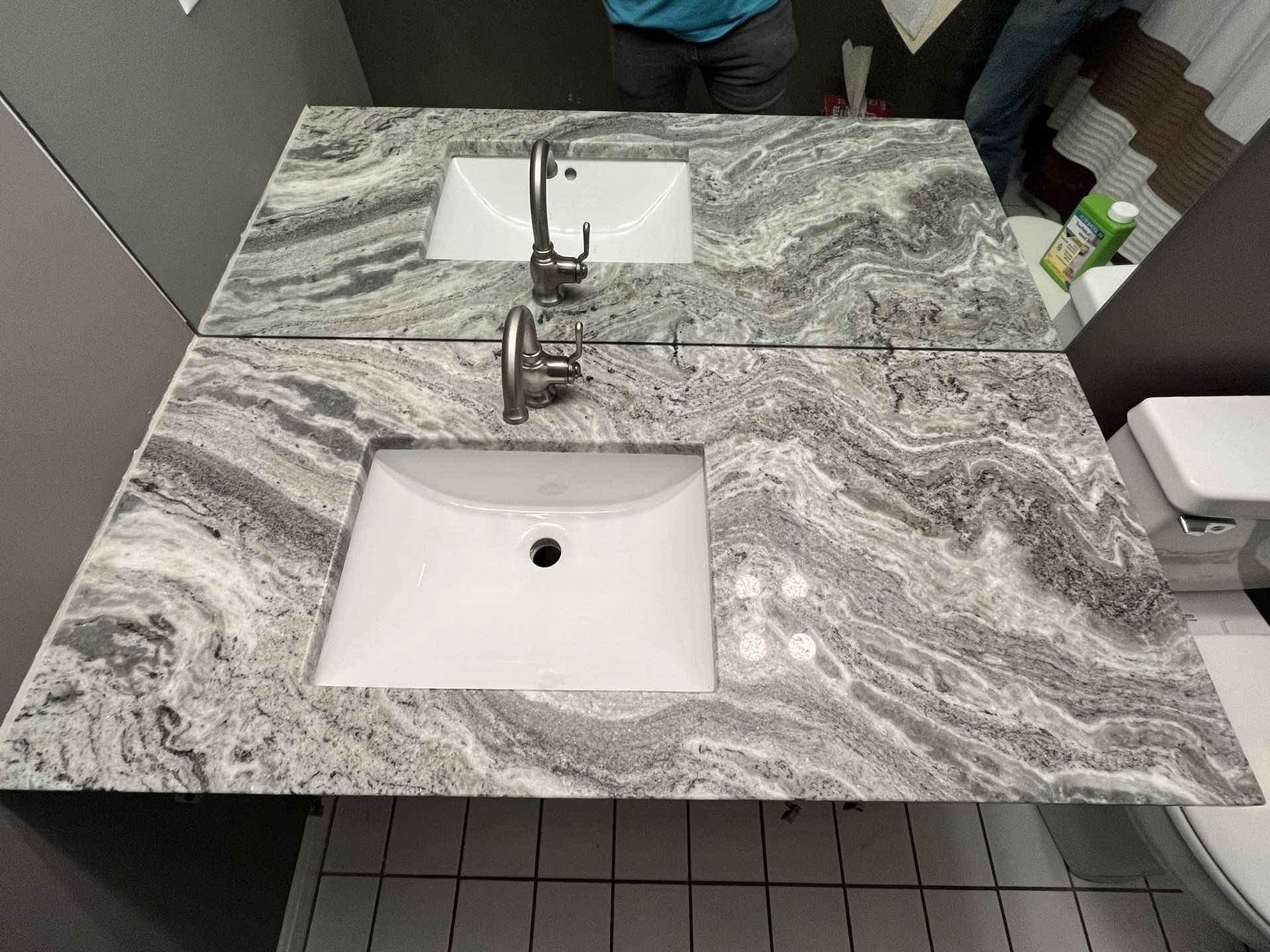 A bathroom with a sink, mirror, and toilet