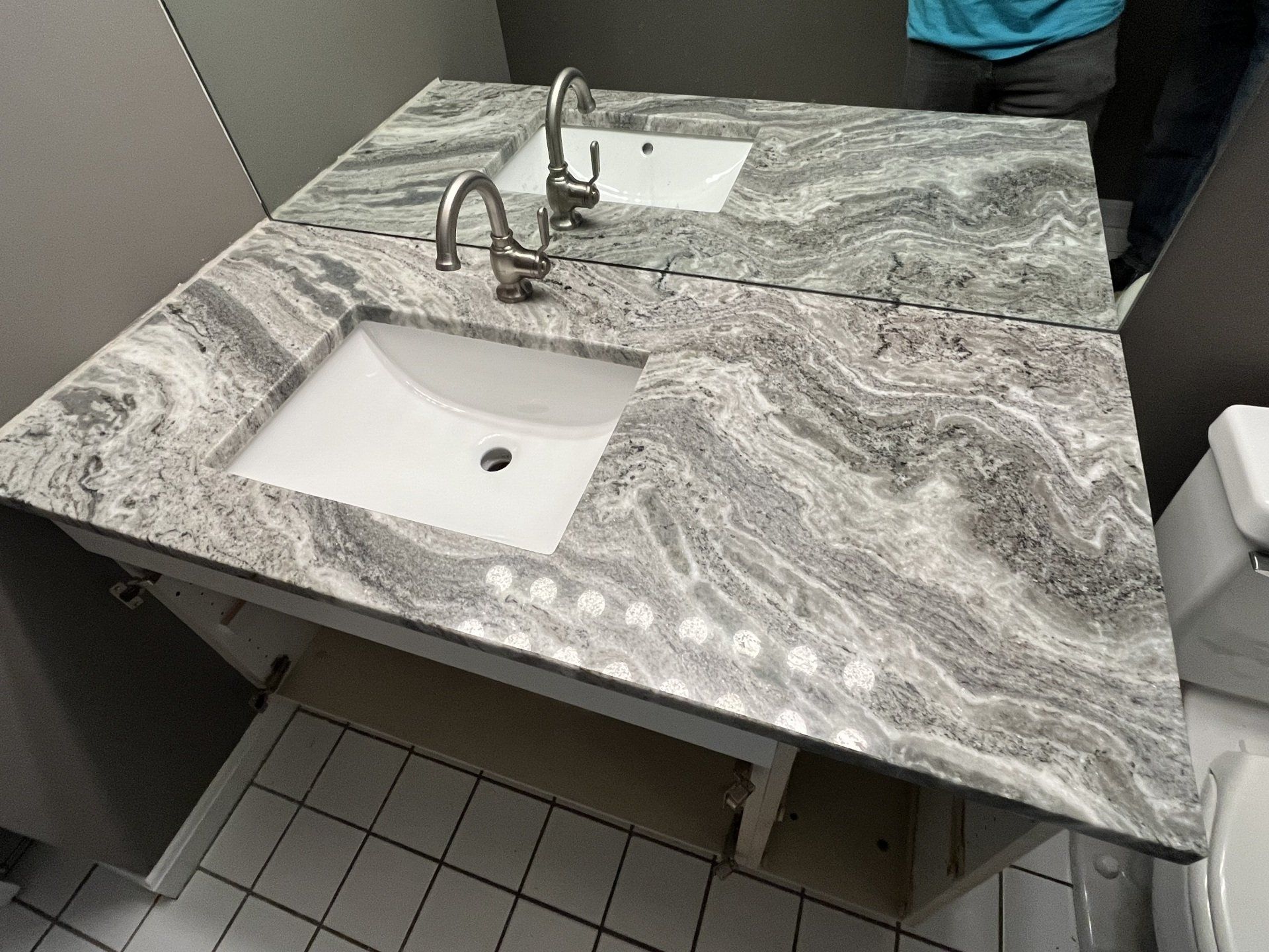 A bathroom with a sink and marble countertop