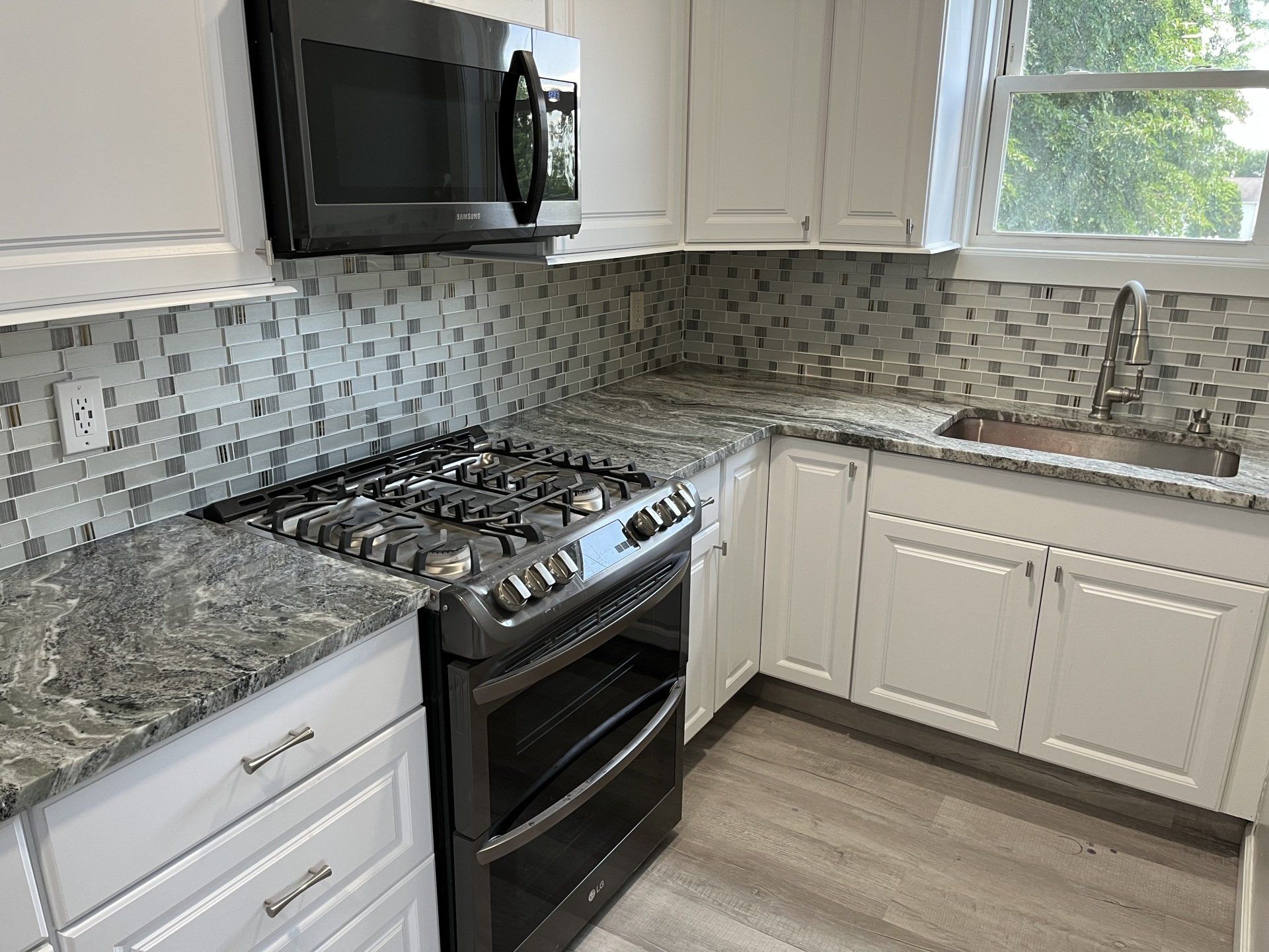A kitchen with gray and white marble countertop
