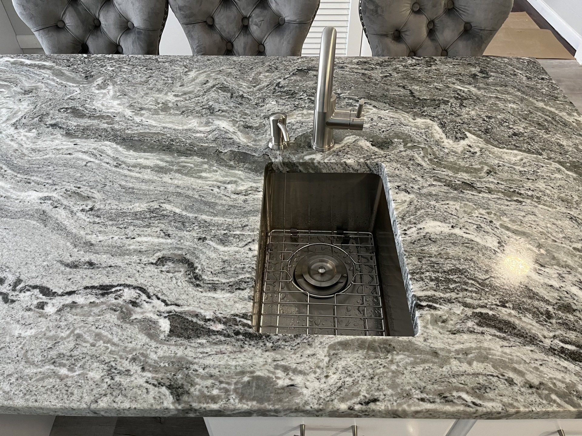 A kitchen sink is sitting on top of a marble countertop