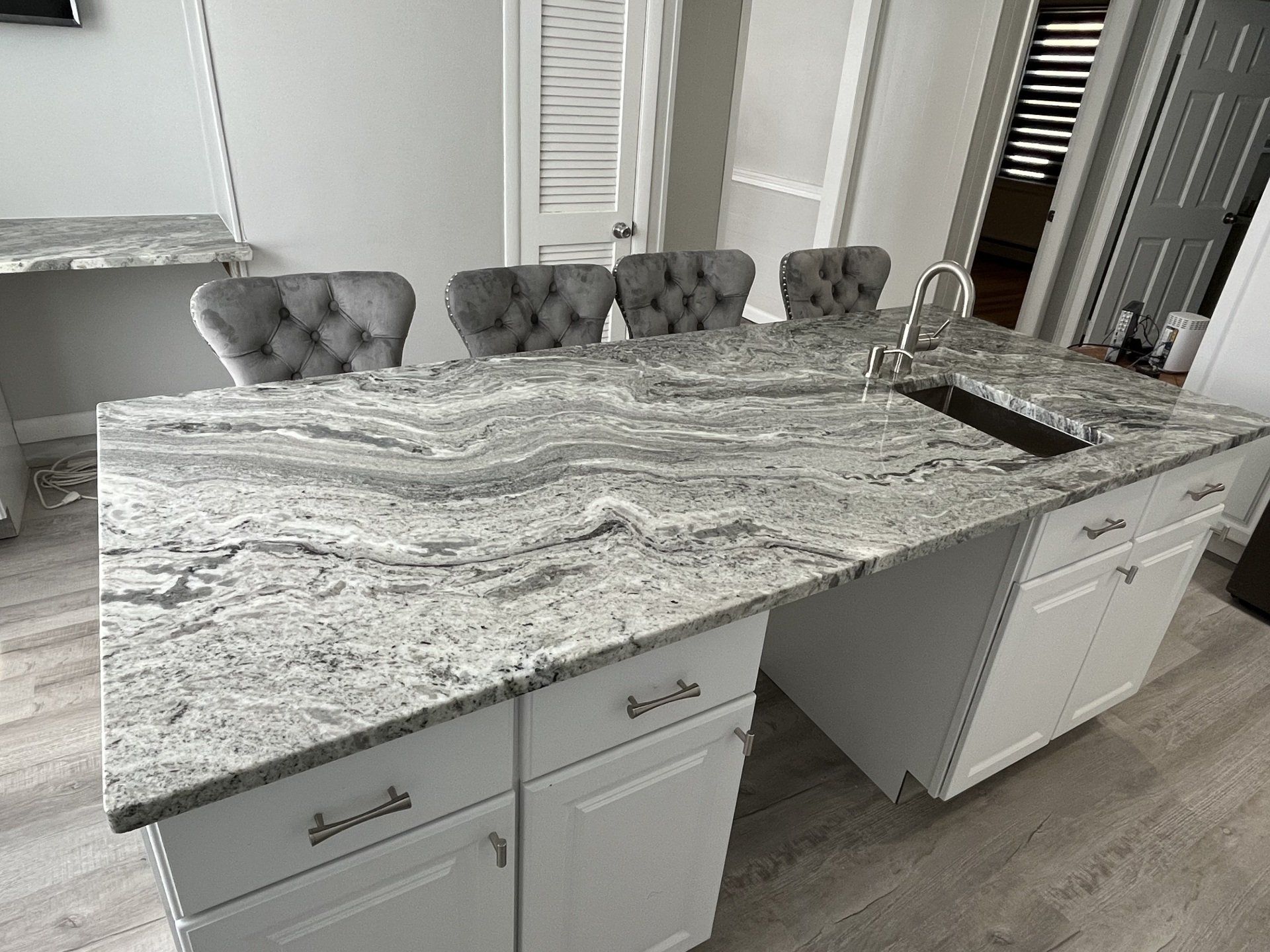 A kitchen with a large marble countertop and a sink