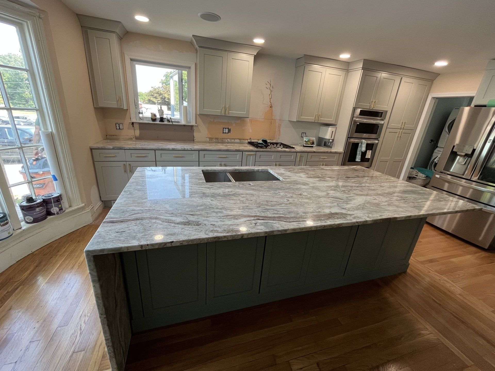 A kitchen that is under construction with a large island in the middle
