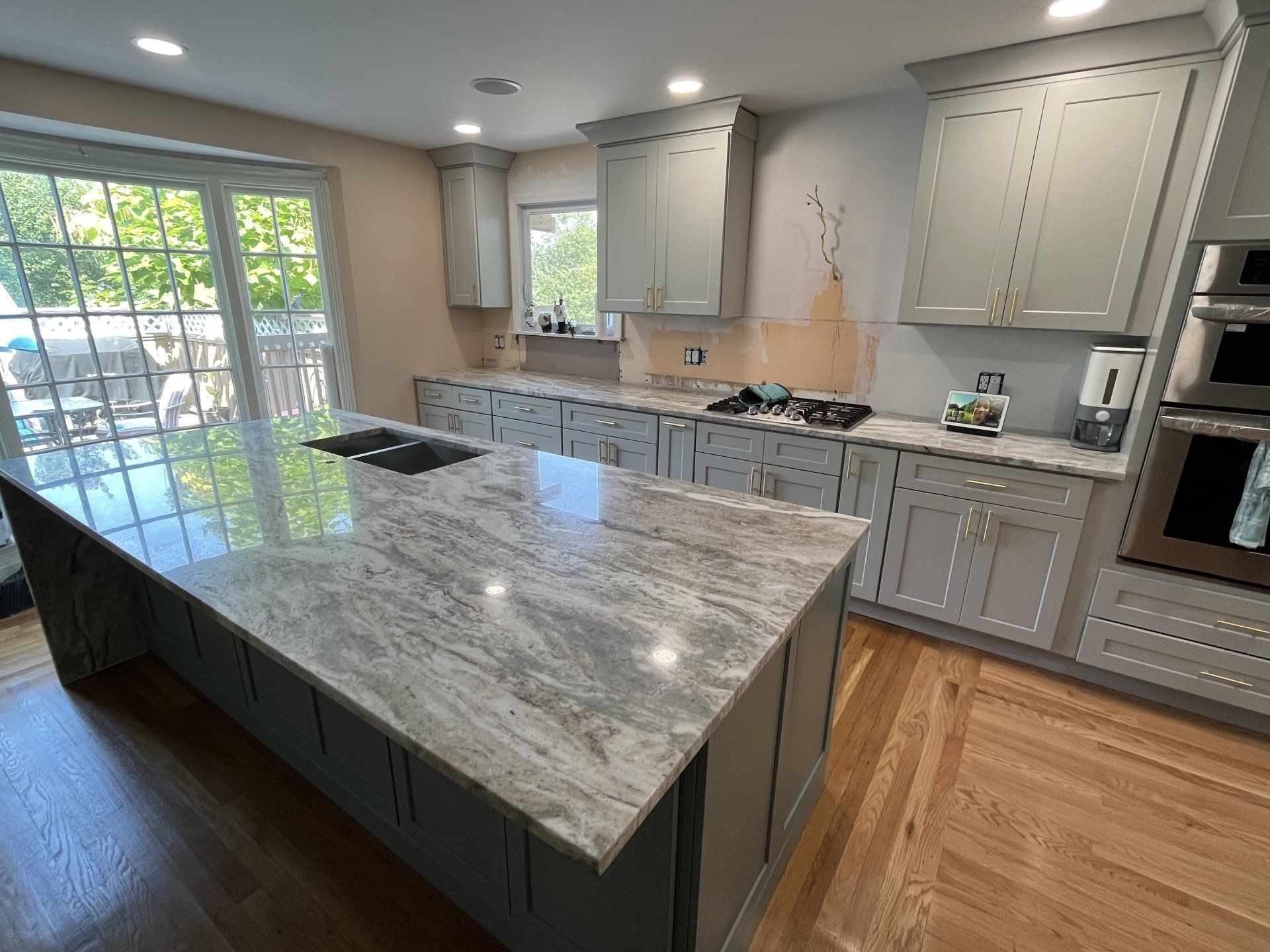 A side view of a kitchen that is under construction with a large island in the middle