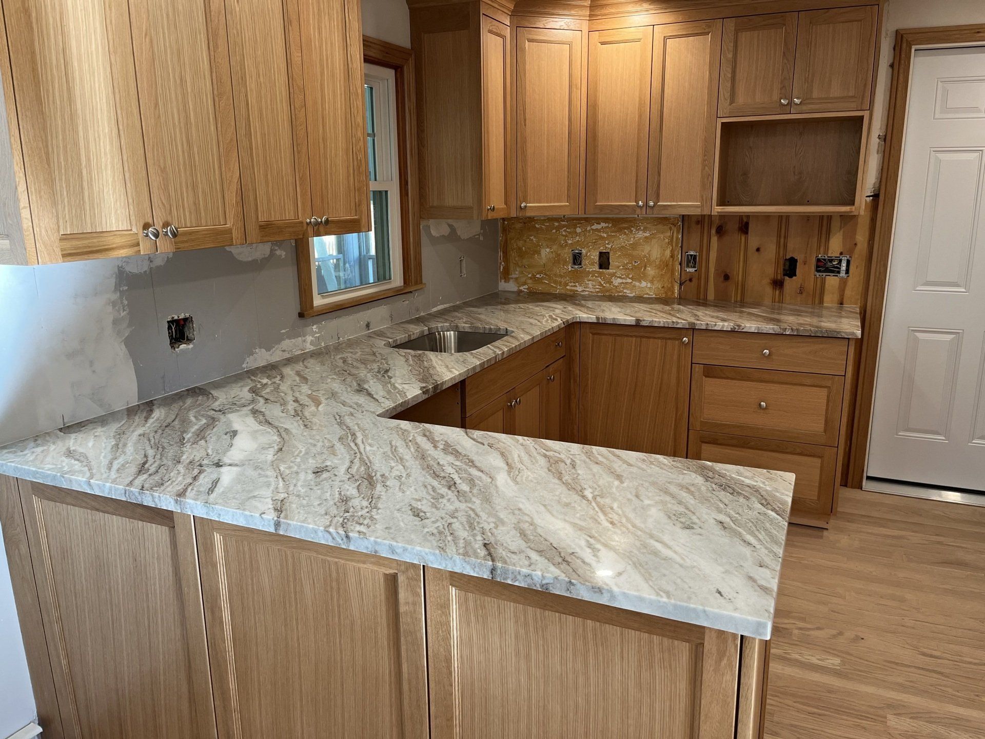 A kitchen that is under construction with wooden cabinets 