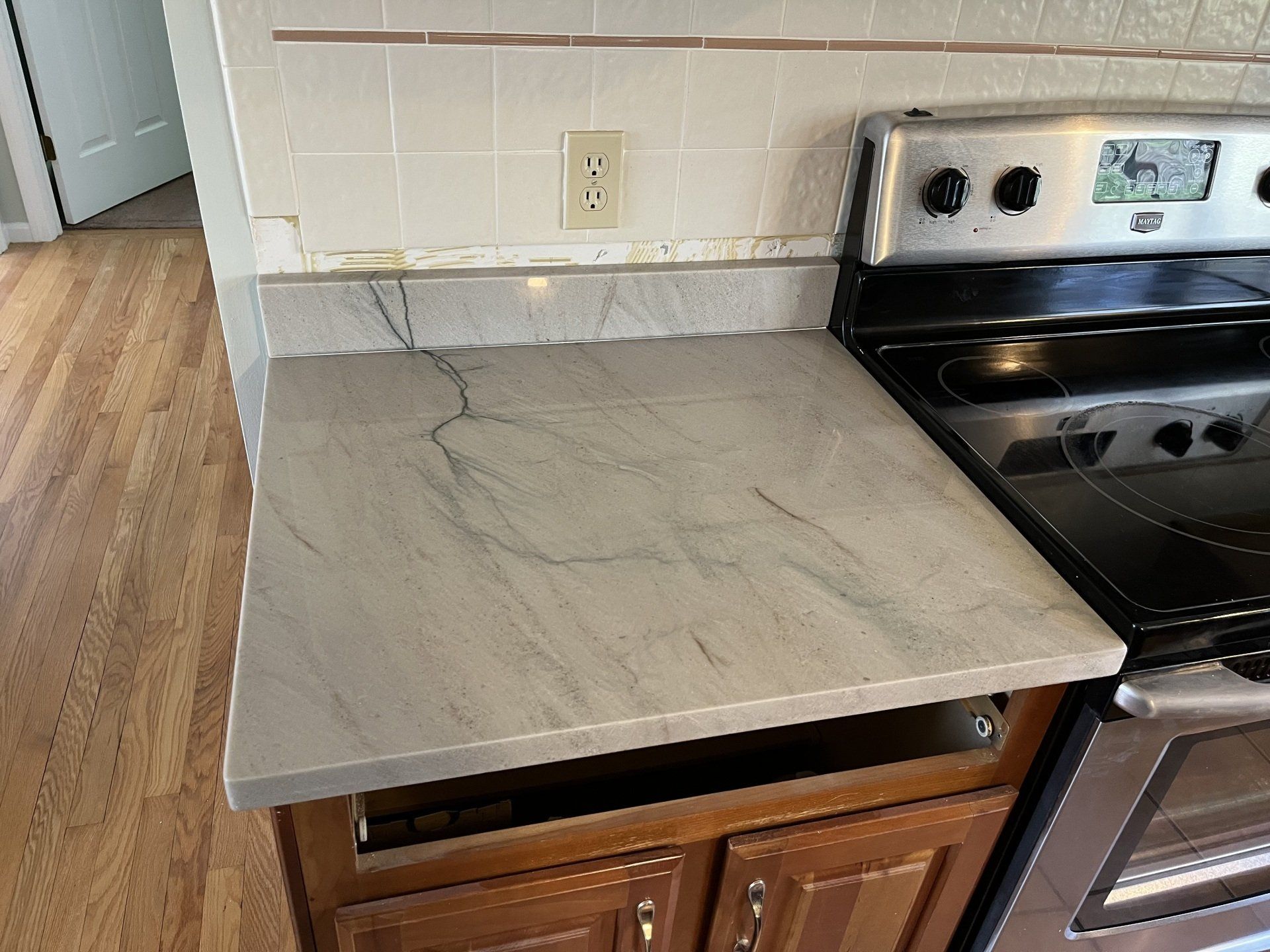 A kitchen with a stove top oven and a quartzite countertop