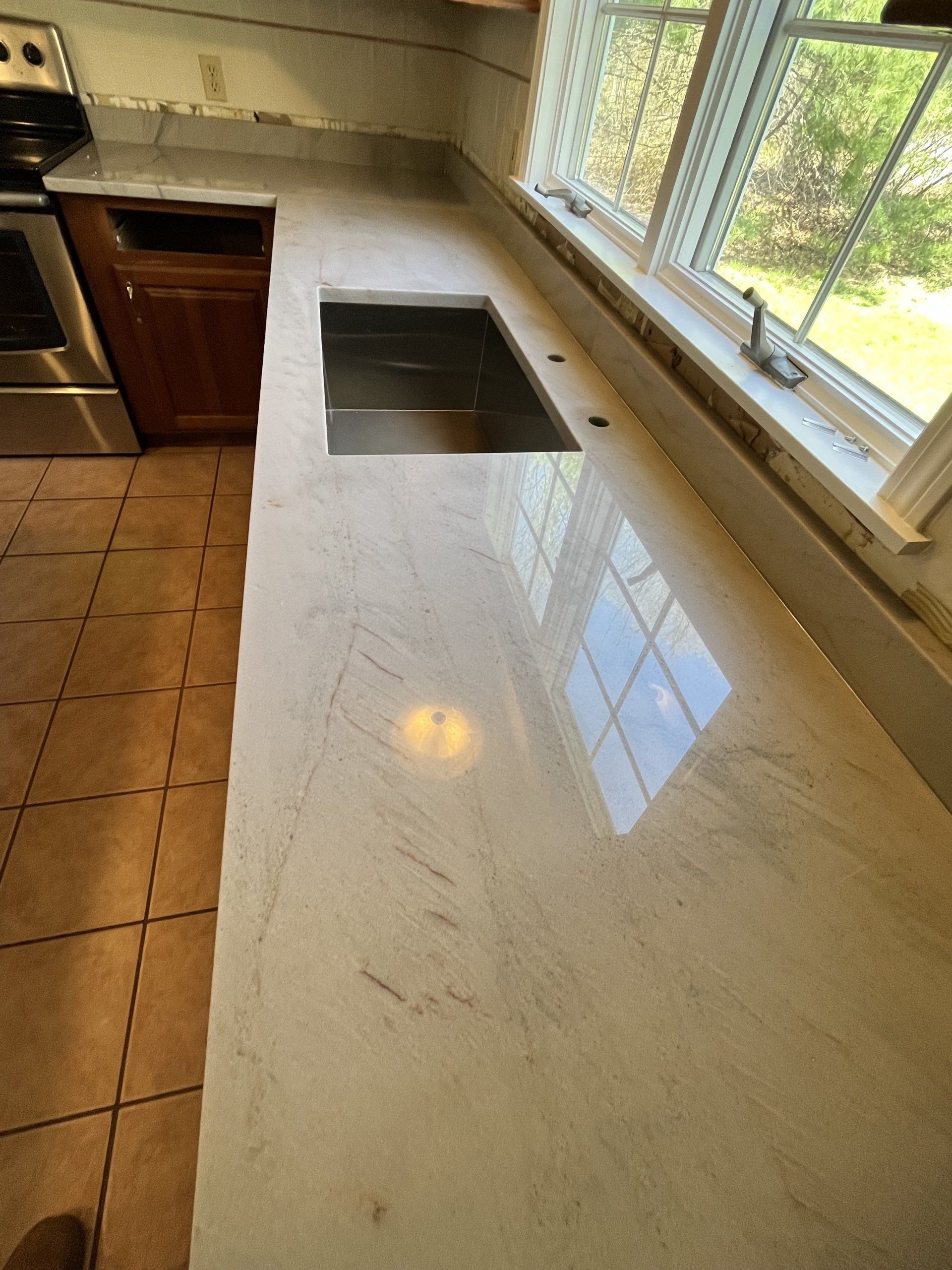 A kitchen counter with a sink and a window