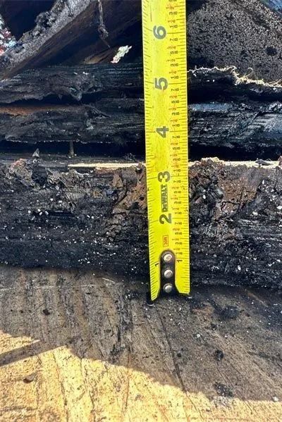 Tape measure showing 2 inches next to layers of black material.