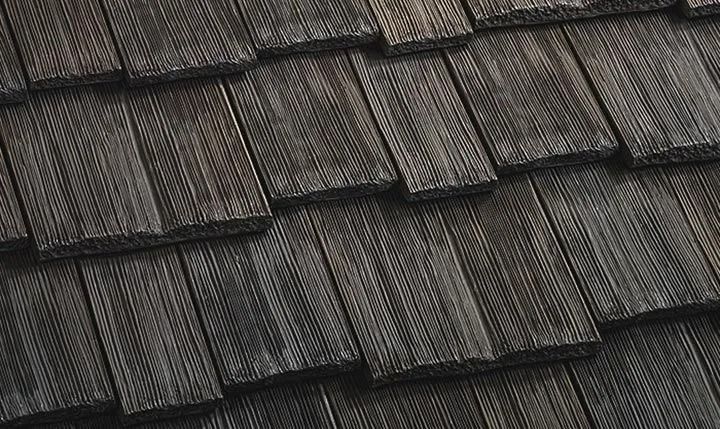 Dark, overlapping wooden shingles, close-up view.