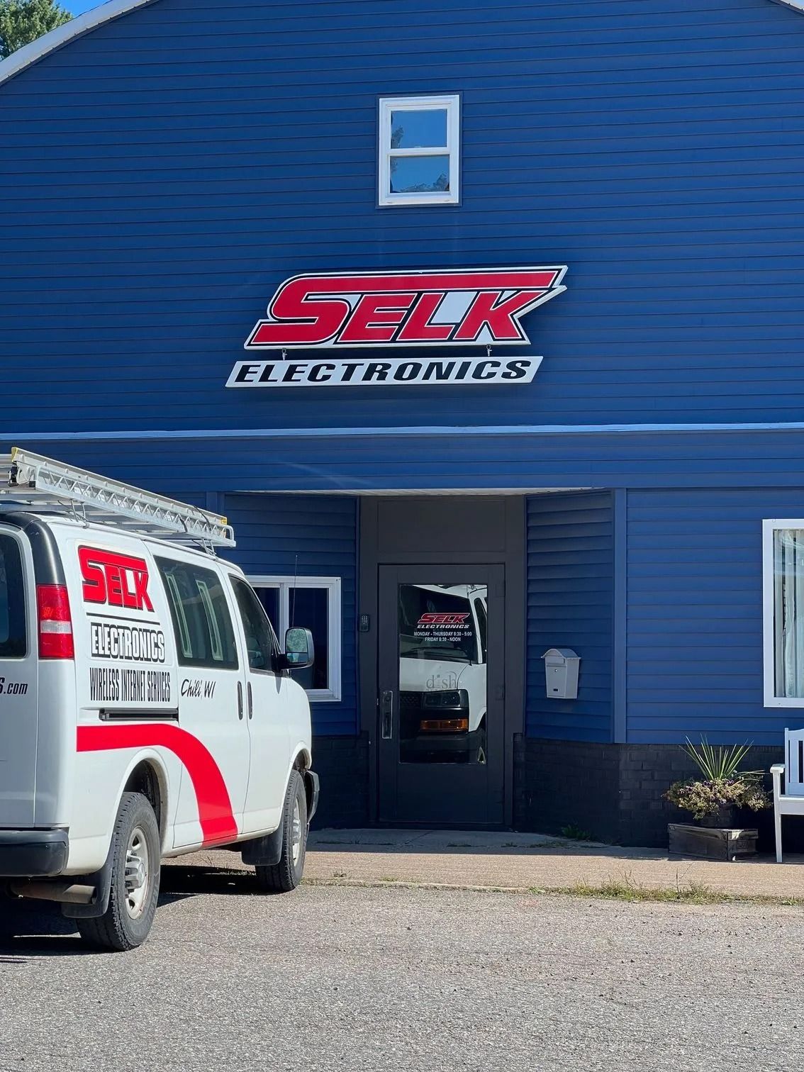 SELK Electronics building with a white service van parked in front.
