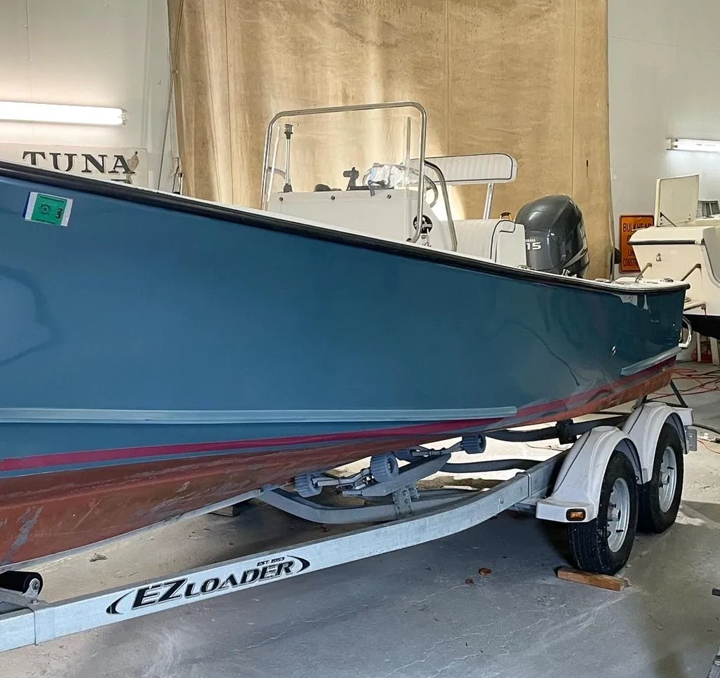Blue boat on a trailer in a shop; EZ Loader trailer.