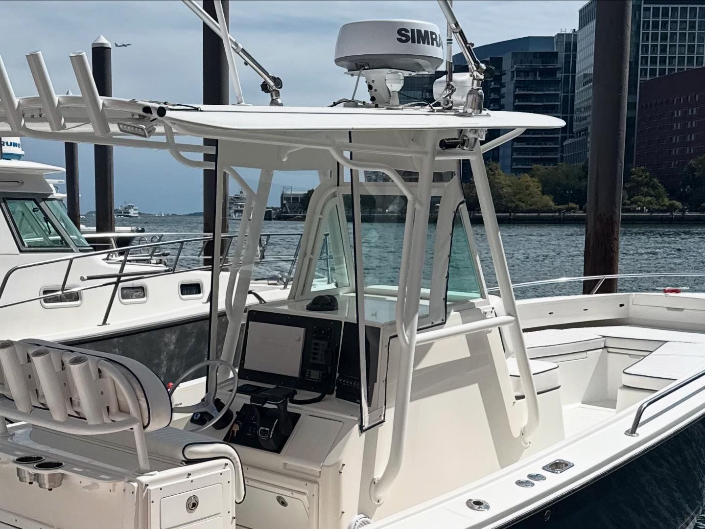 White motorboat docked at a marina with radar dome and navigation equipment.