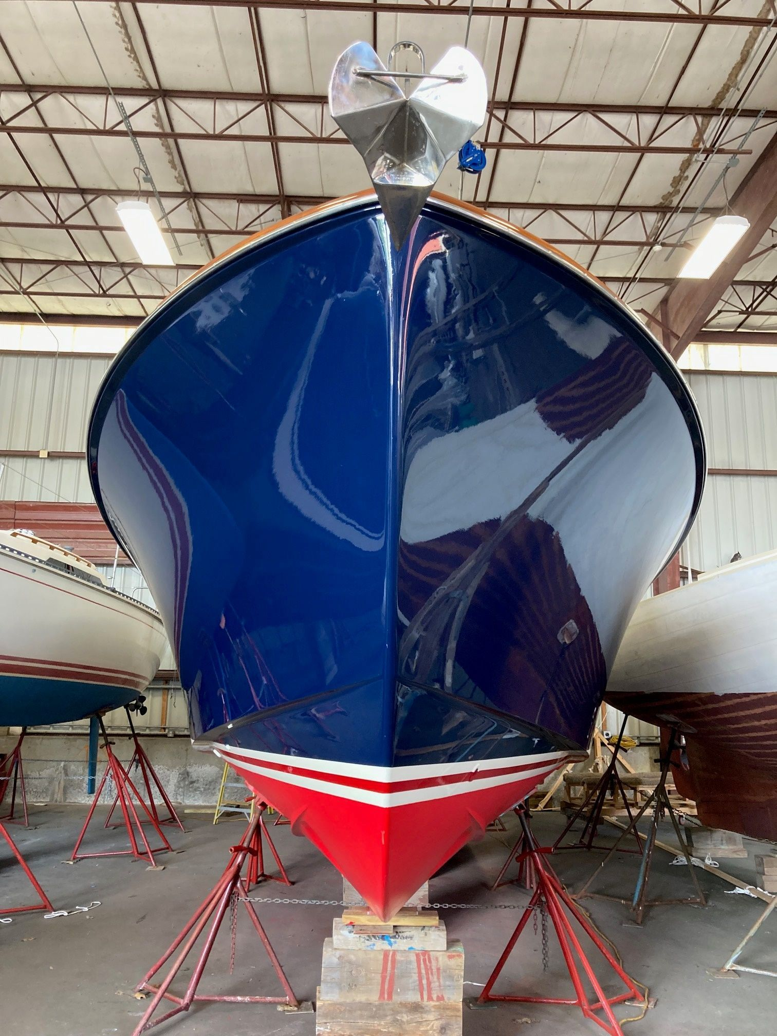 Blue and red boat hull in a warehouse.