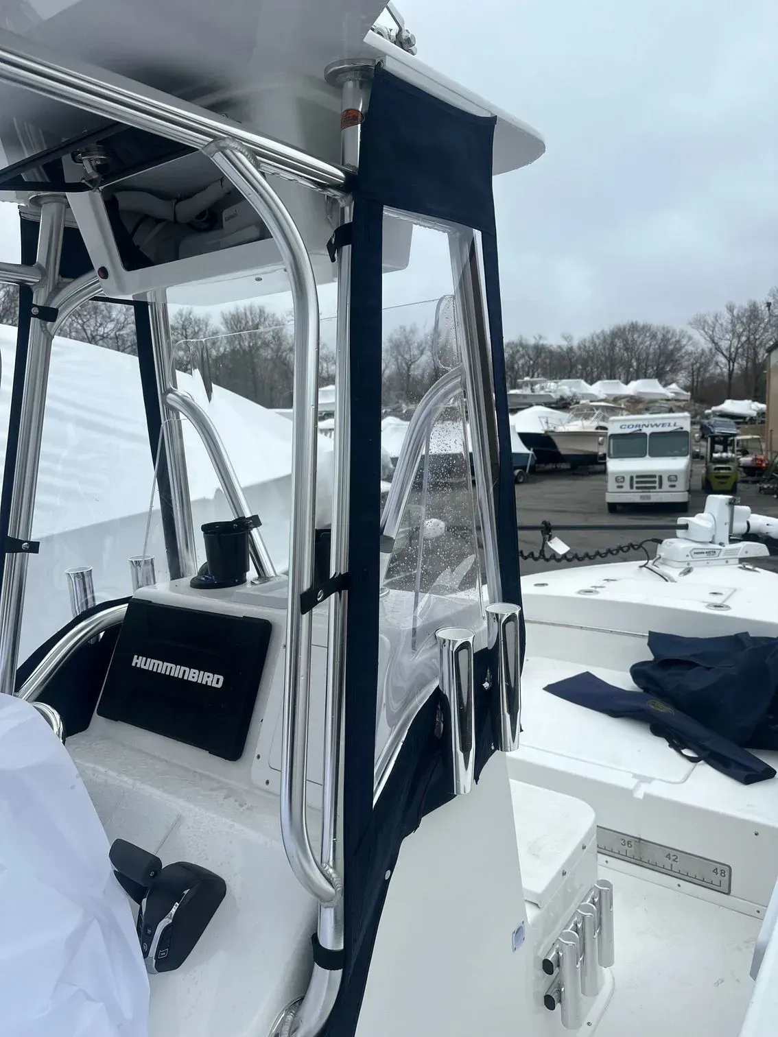 Boat cockpit with clear enclosure and black trim, on a snowy day.