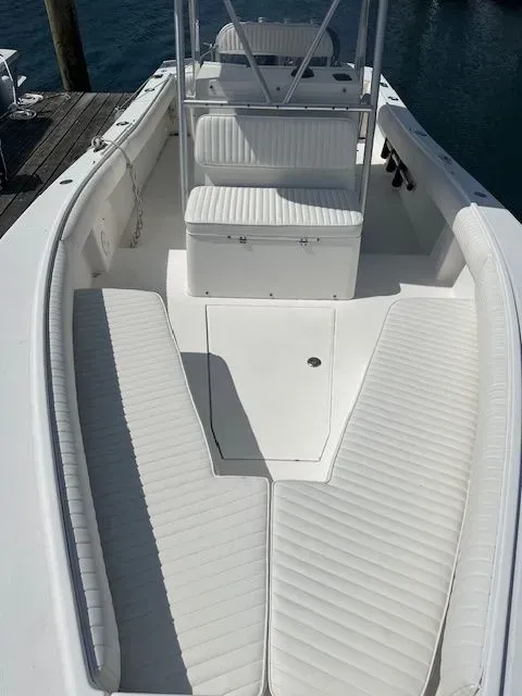 White boat interior with bench seating and a cooler.