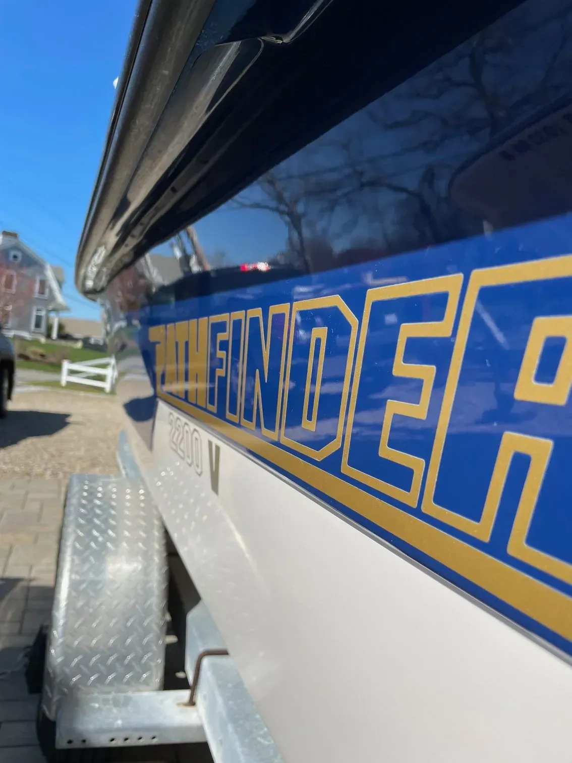 Close-up, angled view of a boat hull labeled PATHFINDER on a trailer outdoors in bright sunlight.