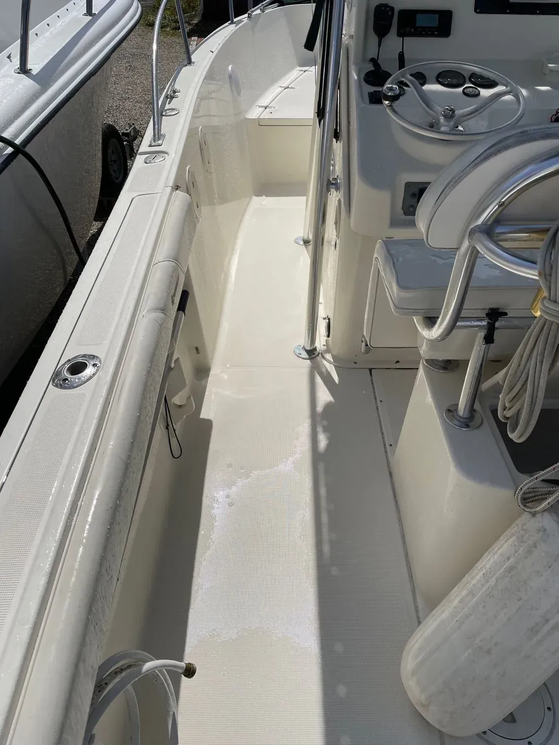 A high-angle view of the deck and center console of a white center console fishing boat.