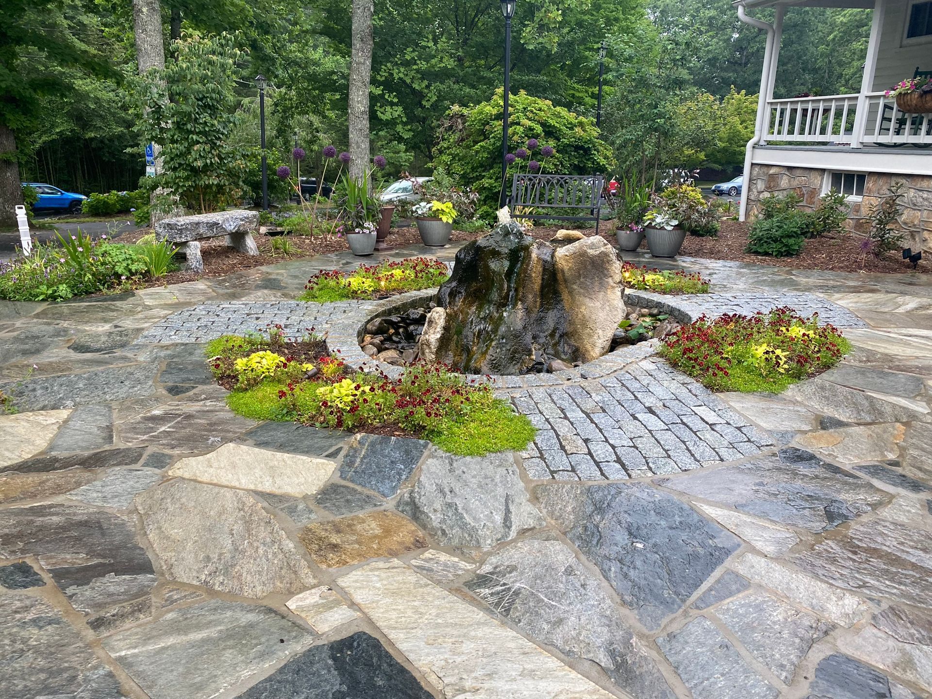 A stone patio with a fountain in the middle of it.