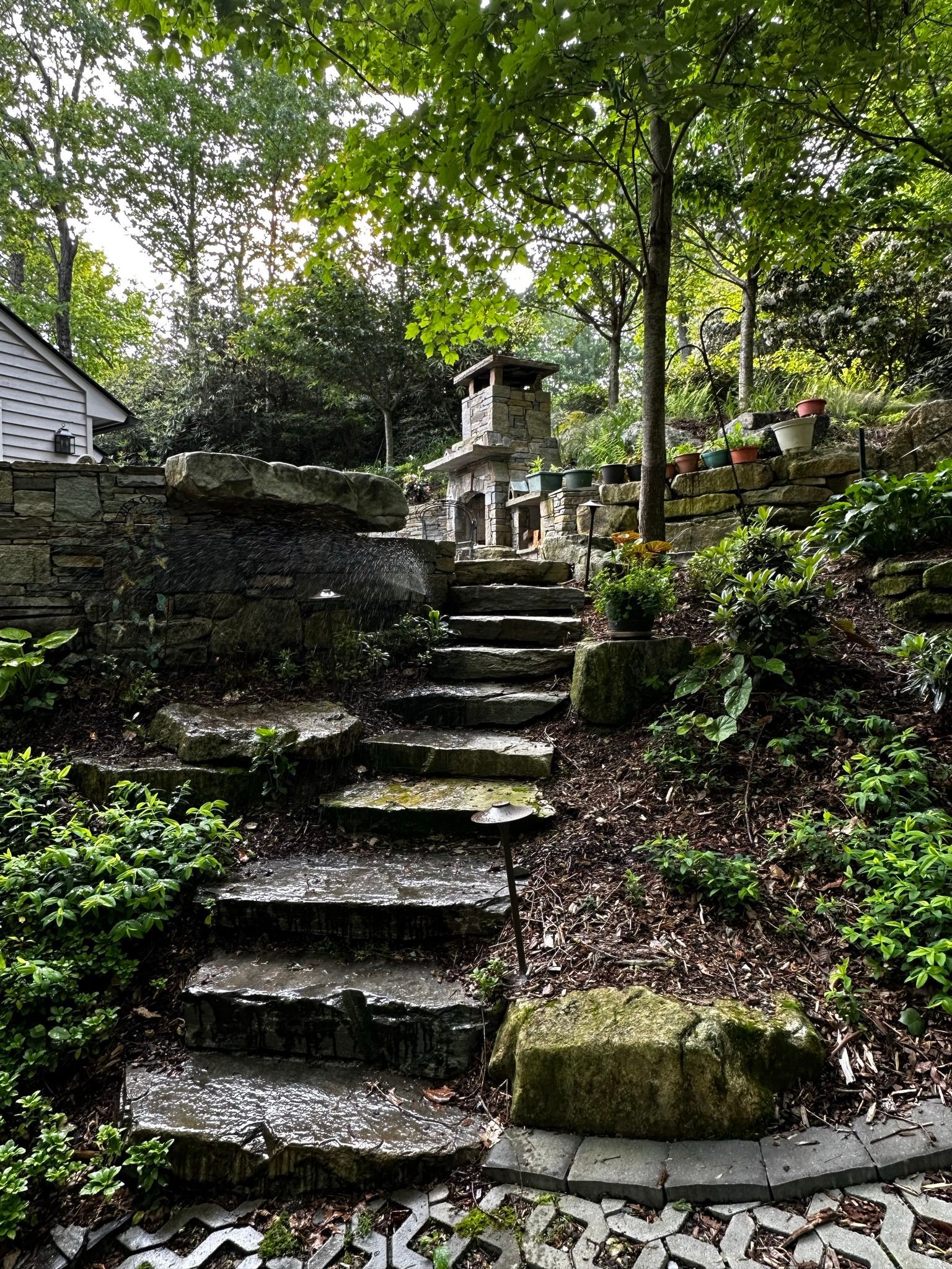 A stone staircase leading up to a house in the woods.