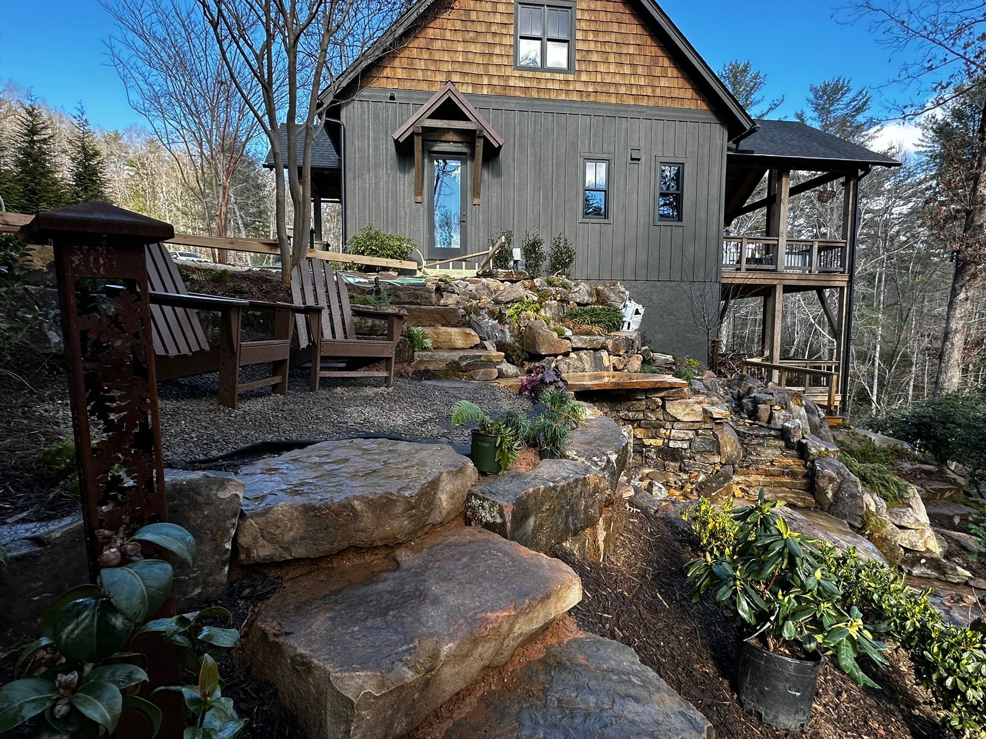 A house with stairs leading up to it in the woods.