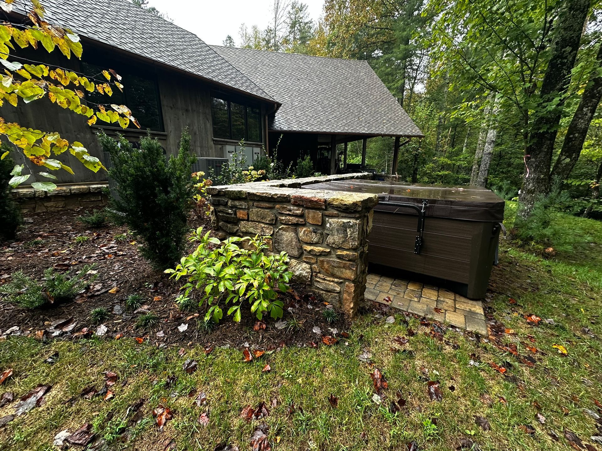 A large trunk is sitting in the grass in front of a house.