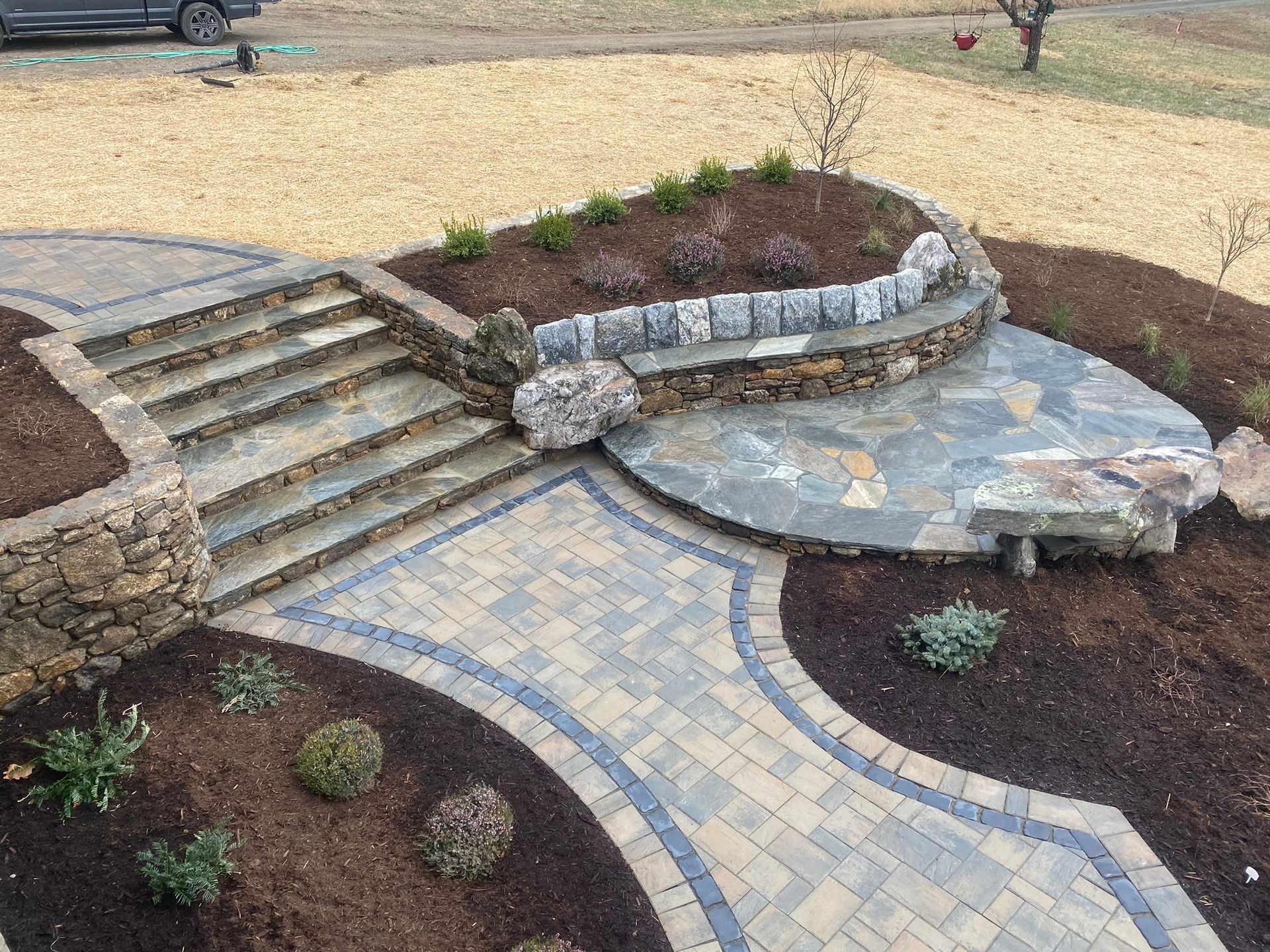 A patio with stairs and a bench in the middle of it.