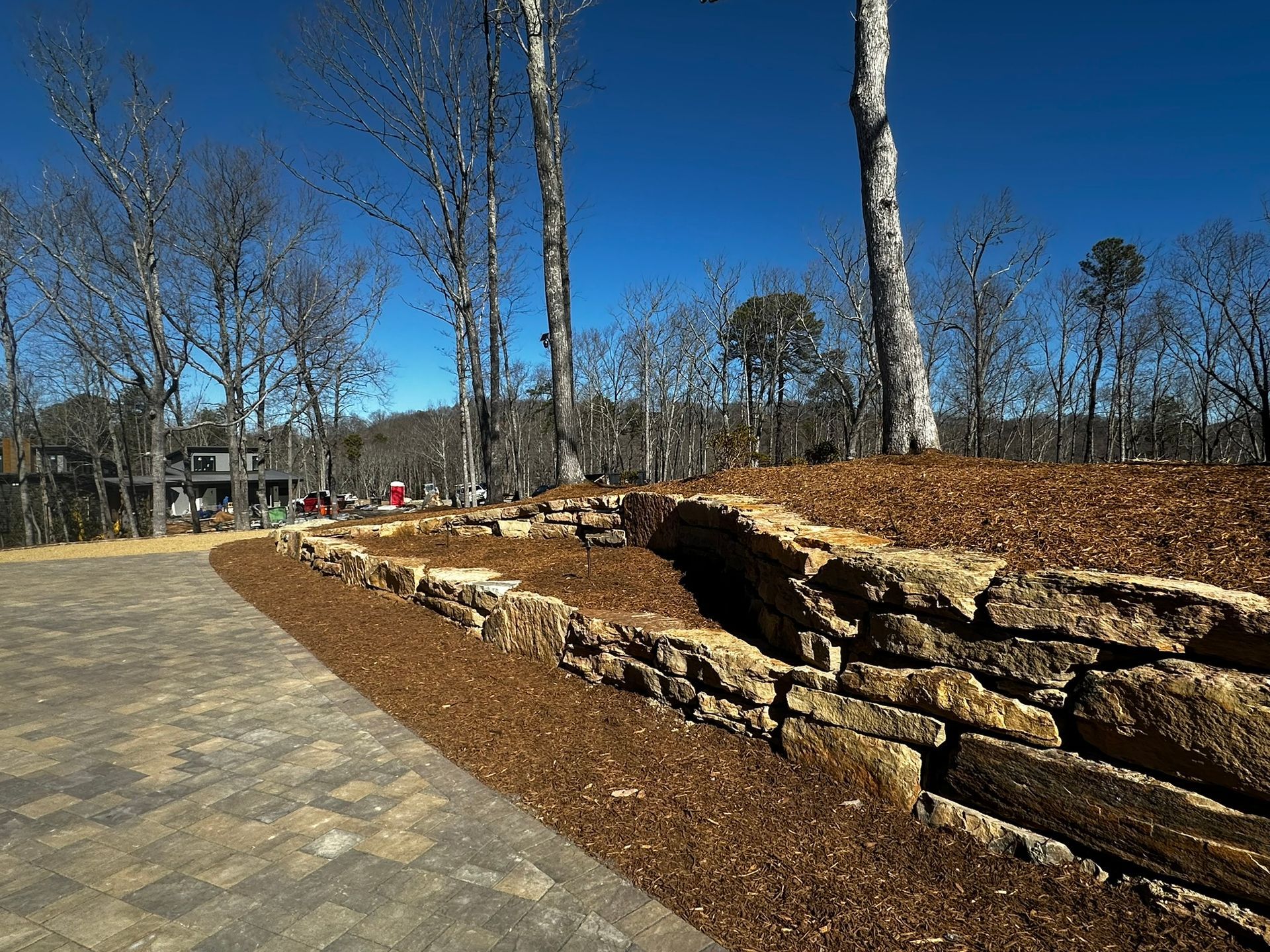 A stone wall is surrounded by trees on a hillside.