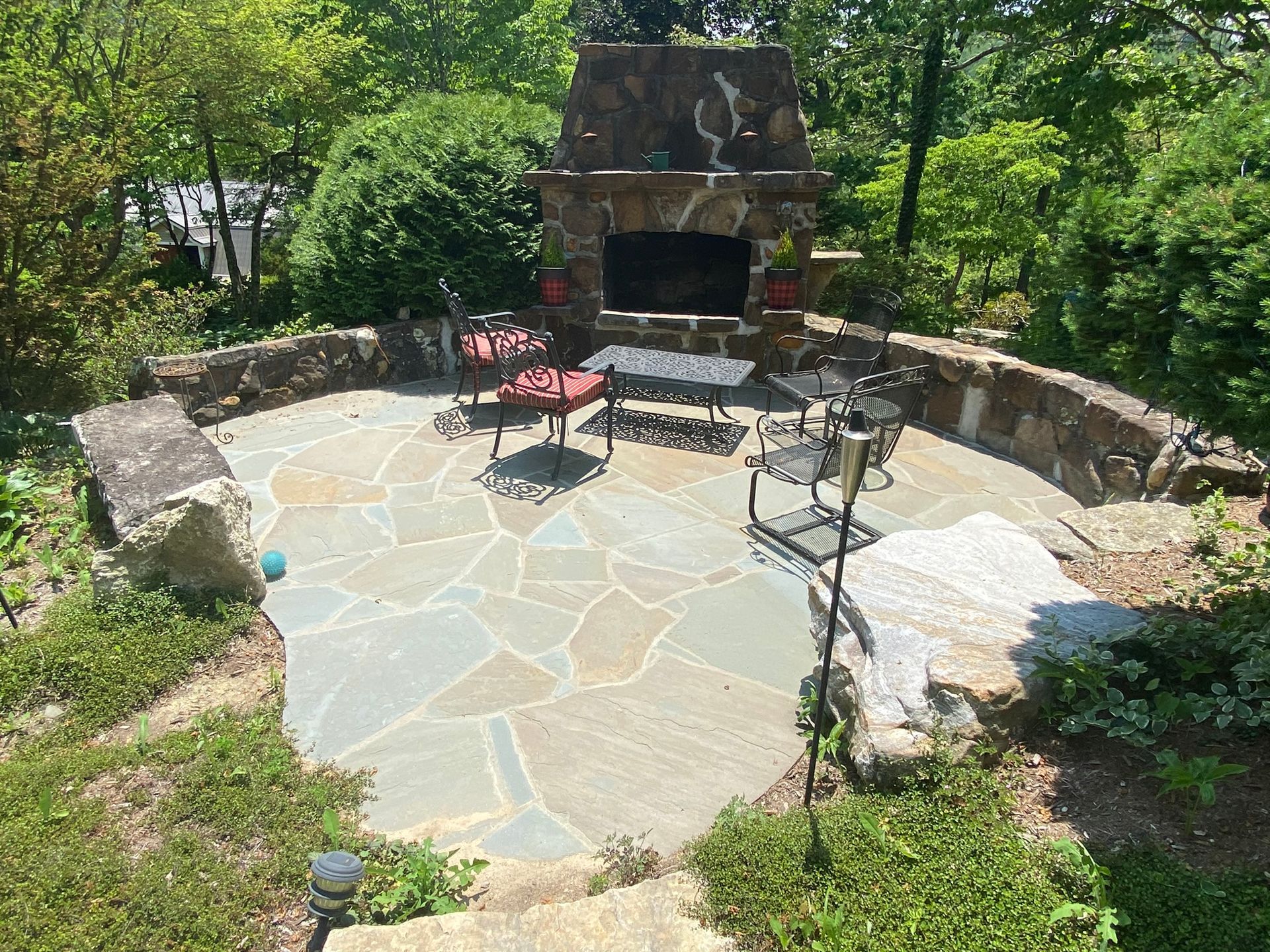 There is a stone fireplace in the middle of the patio.