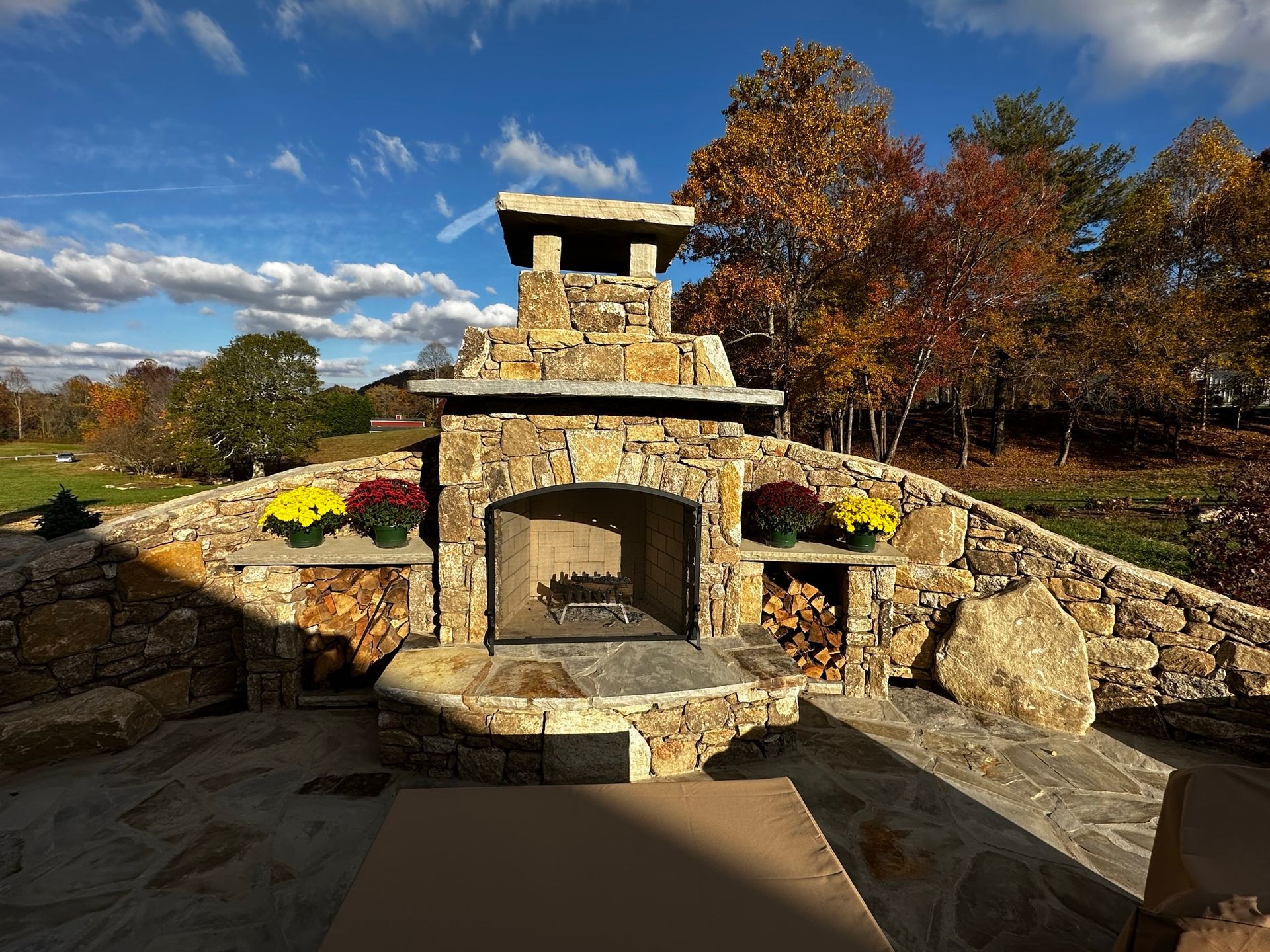 A stone fireplace is surrounded by a stone wall.