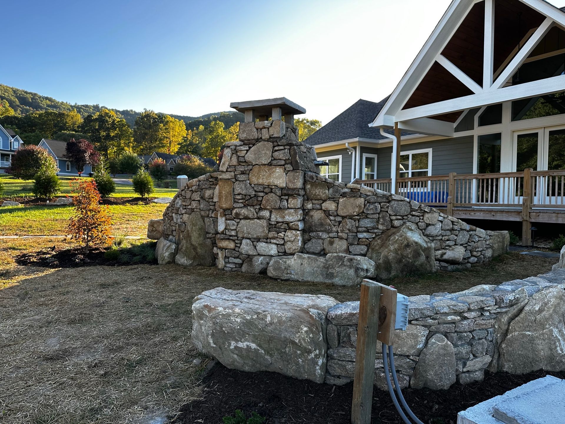 A house with a stone wall in front of it.