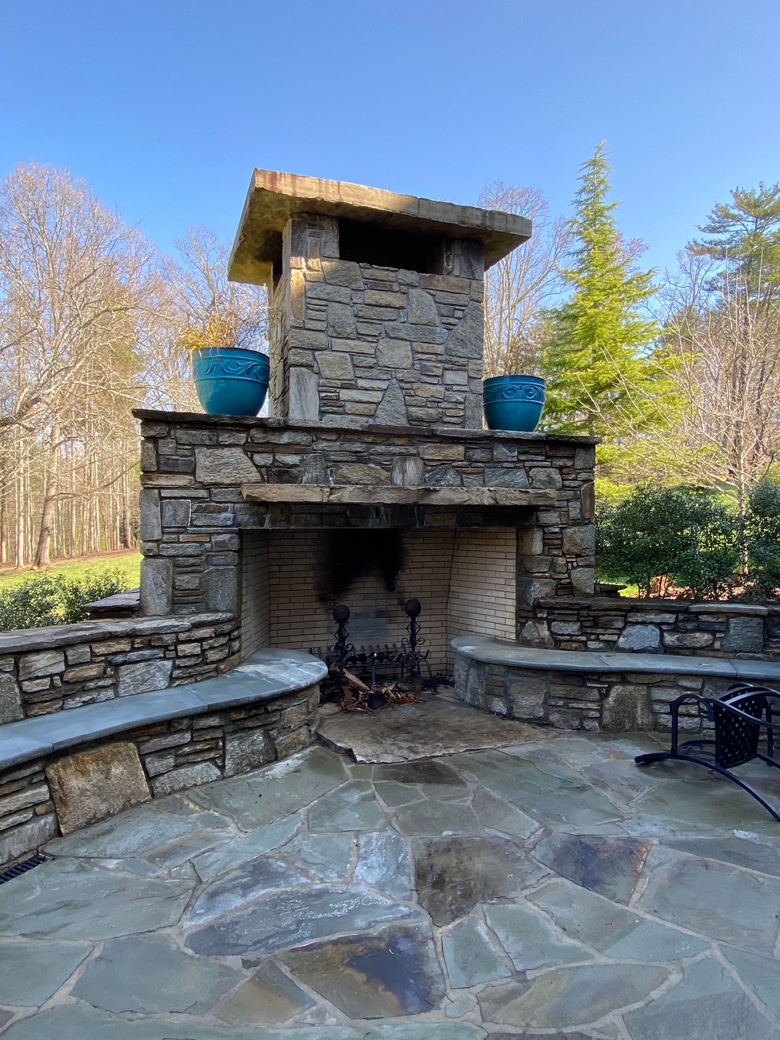 There is a stone fireplace in the middle of the patio.