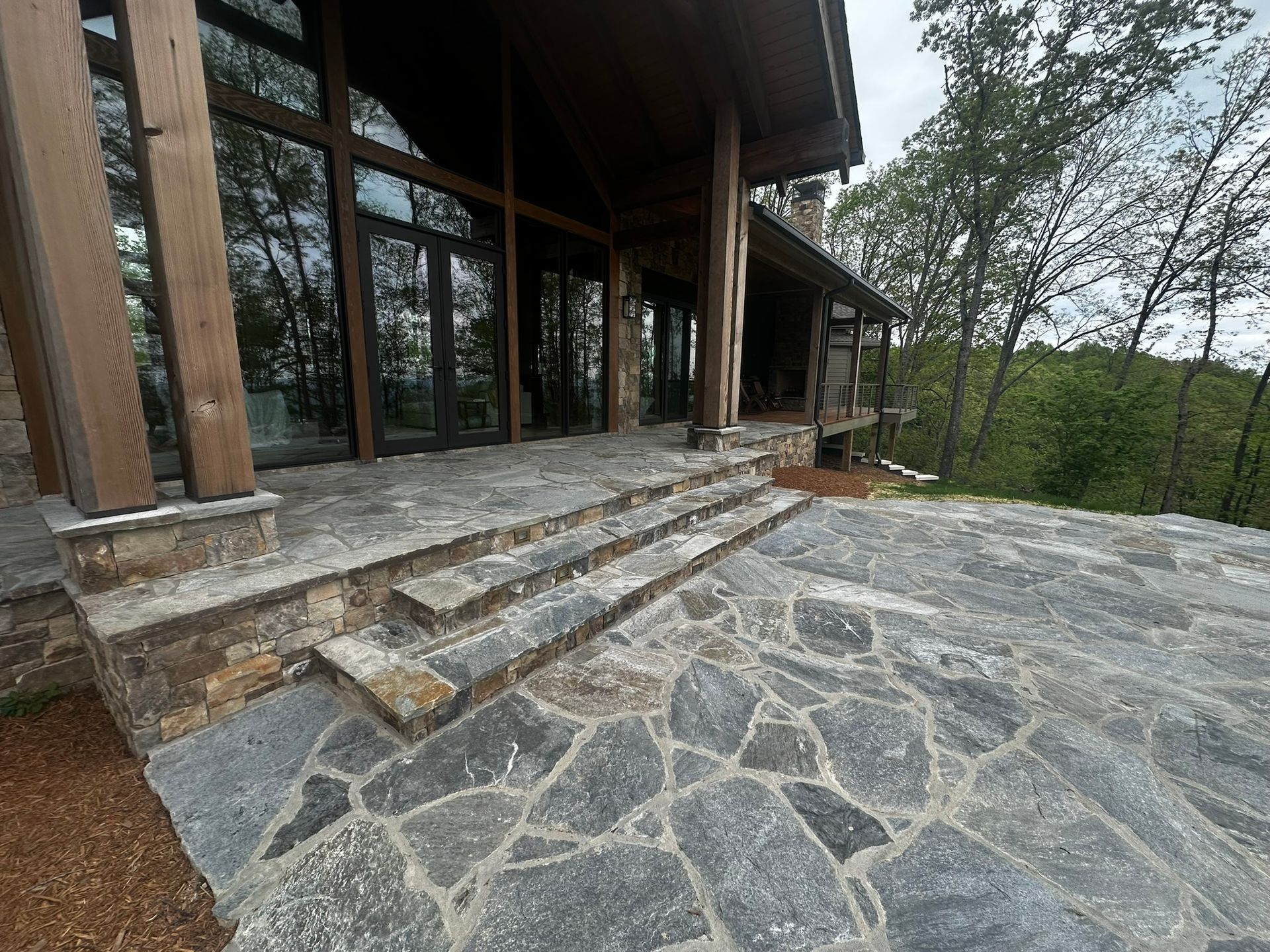 A large house with a stone patio in front of it.