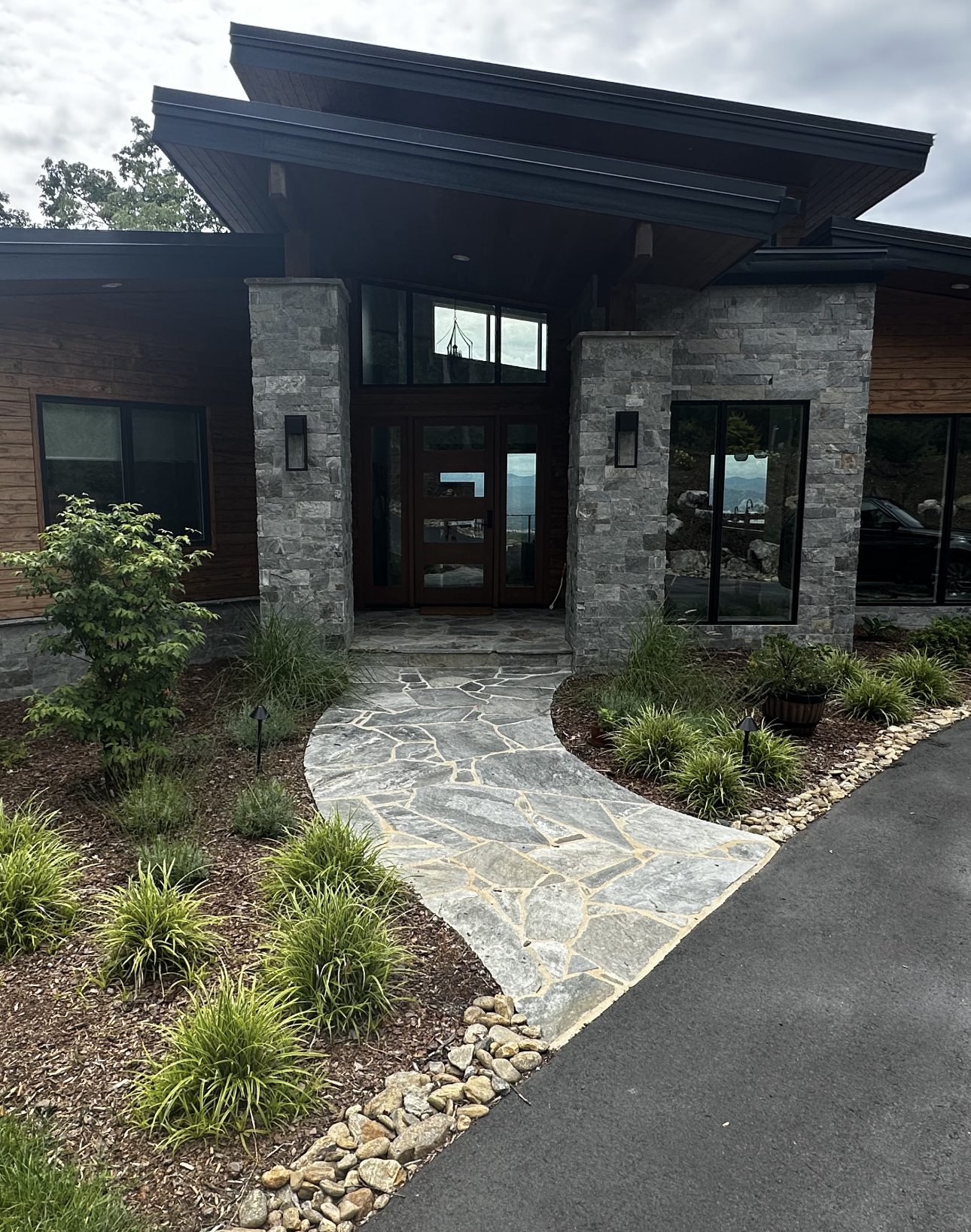 A modern house with a stone walkway leading to the front door.