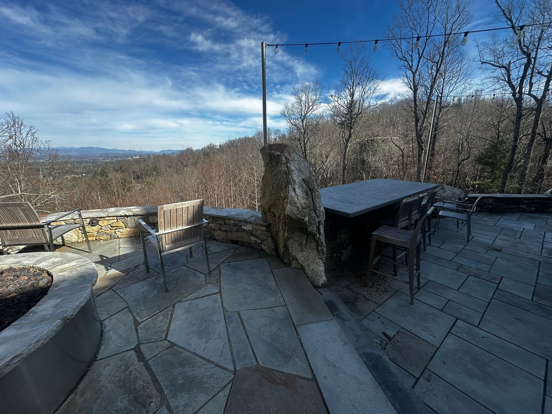 There is a table and chairs on the patio with a view of the mountains.