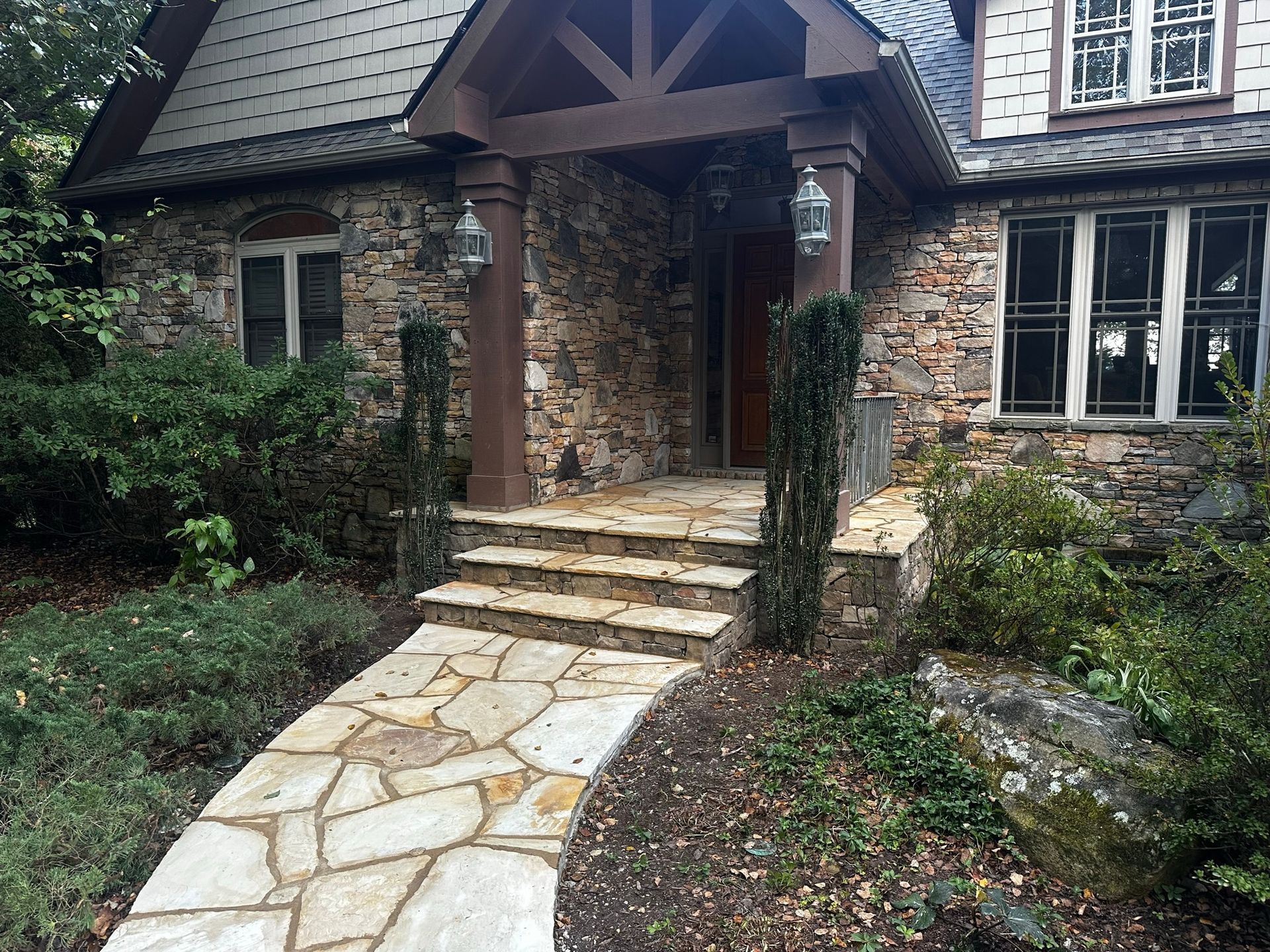A stone walkway leads to the front door of a house.
