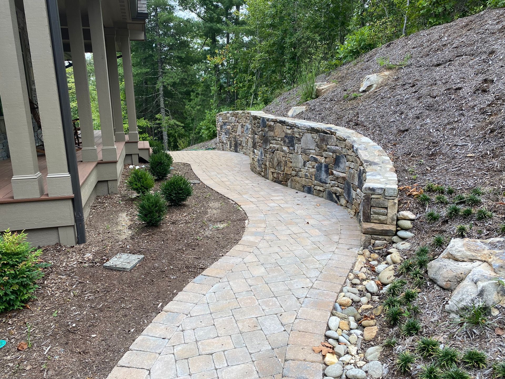 A stone walkway leading to a house on a hill.