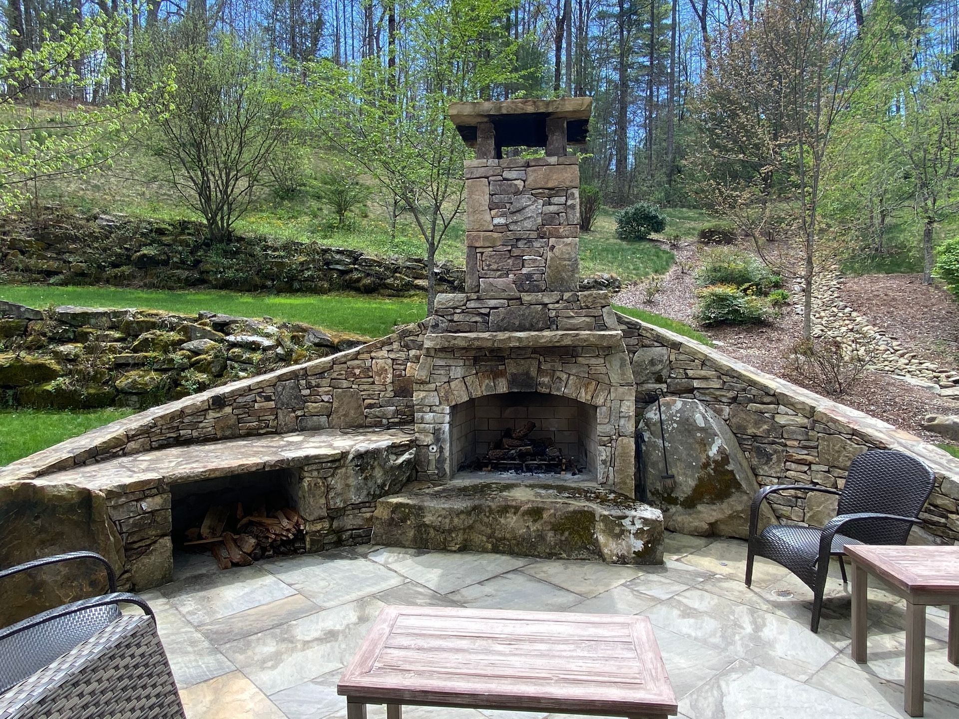 There is a stone fireplace in the middle of the patio.