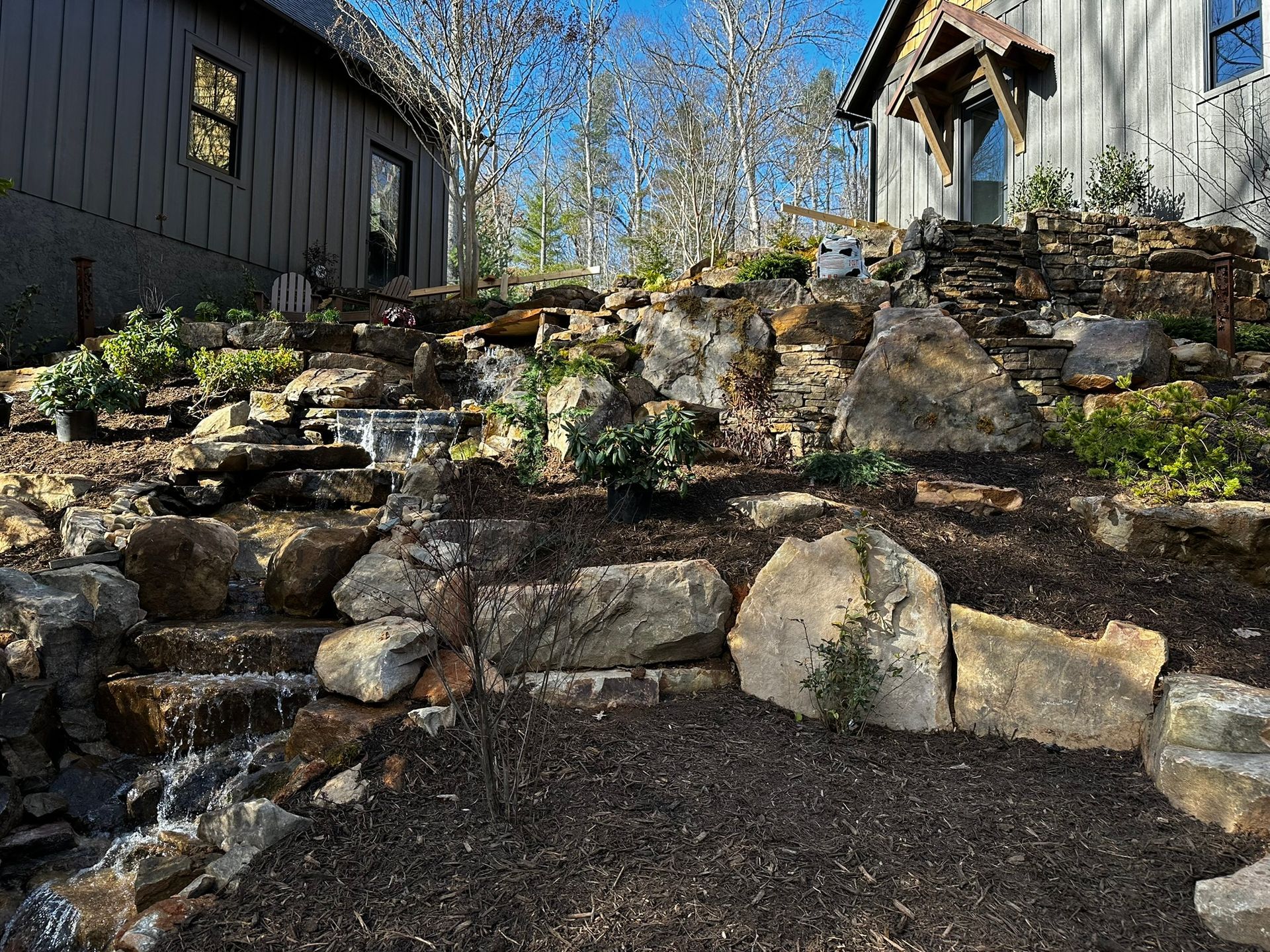 There is a waterfall in the backyard of a house.
