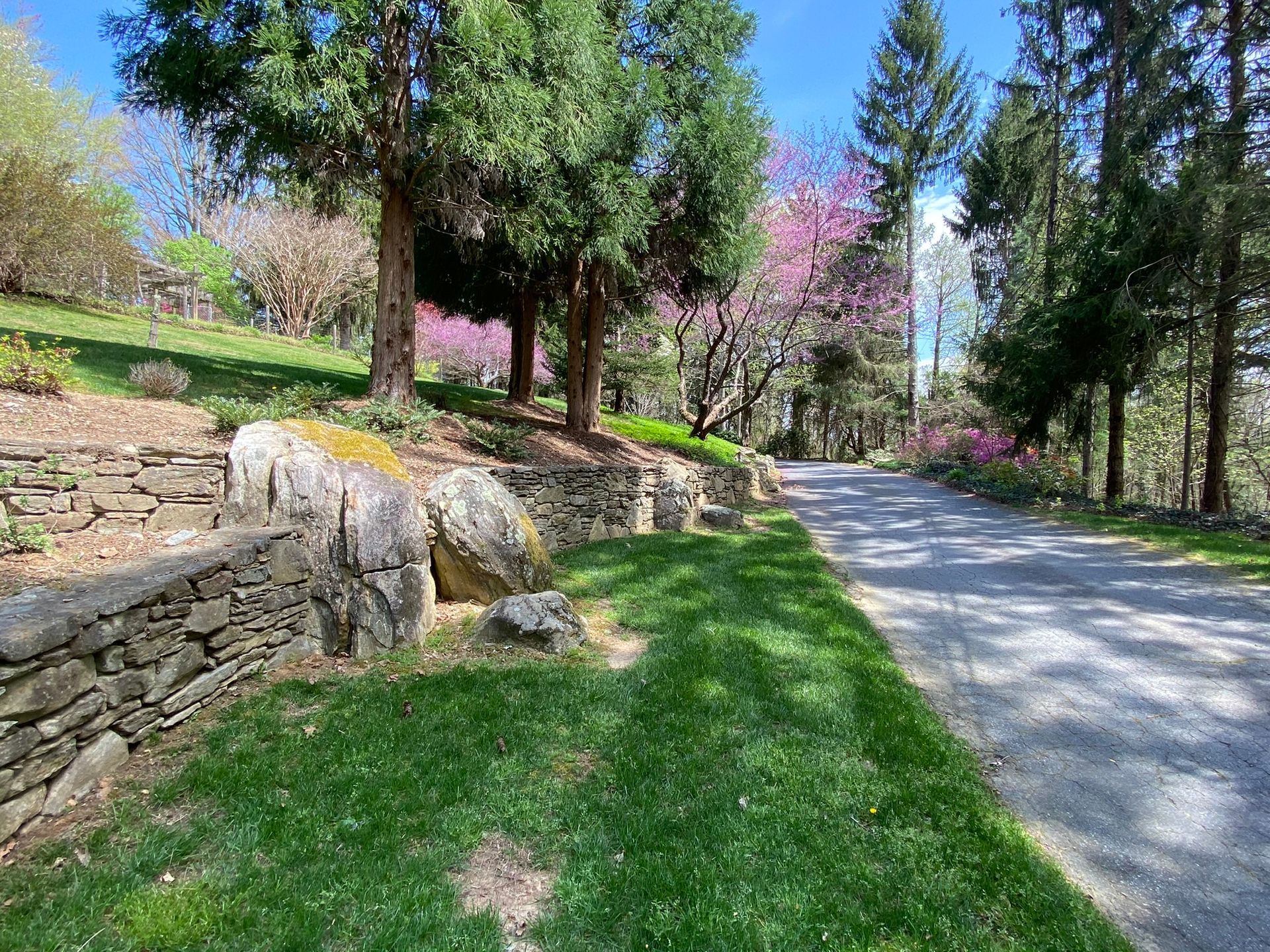 There is a stone wall on the side of the road.