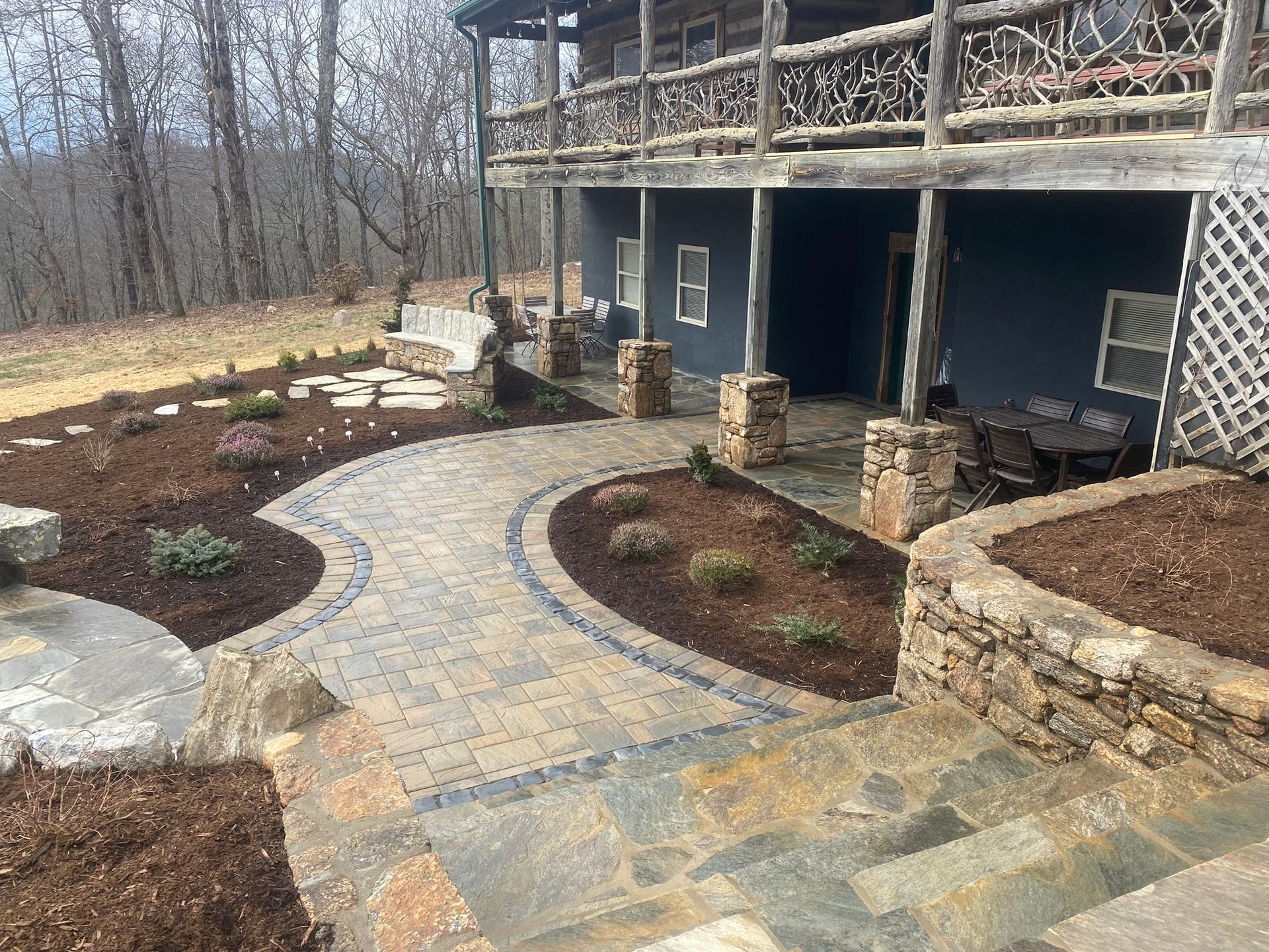 A large house with a patio and stairs in front of it.