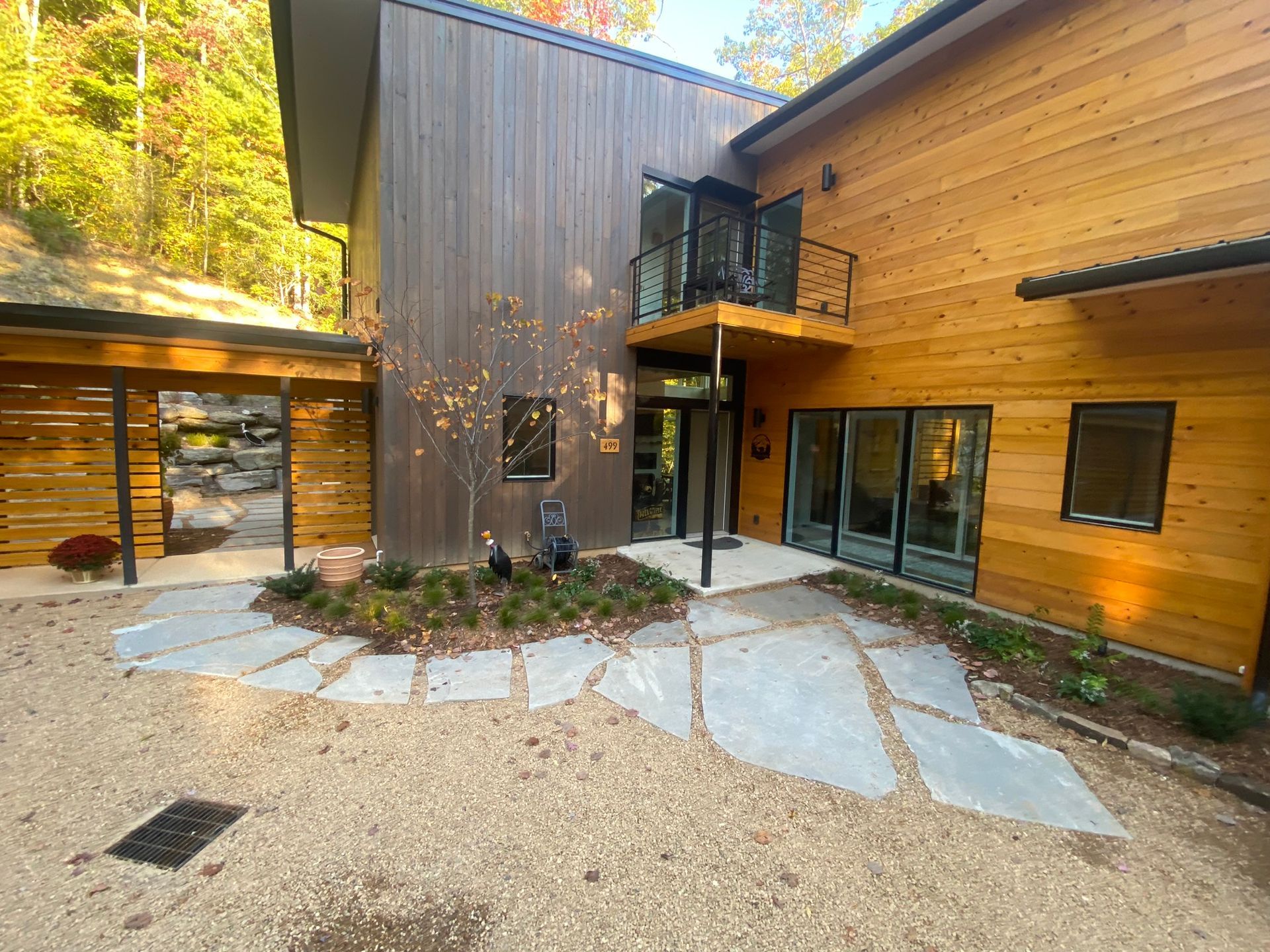 A large wooden house with a patio in front of it.