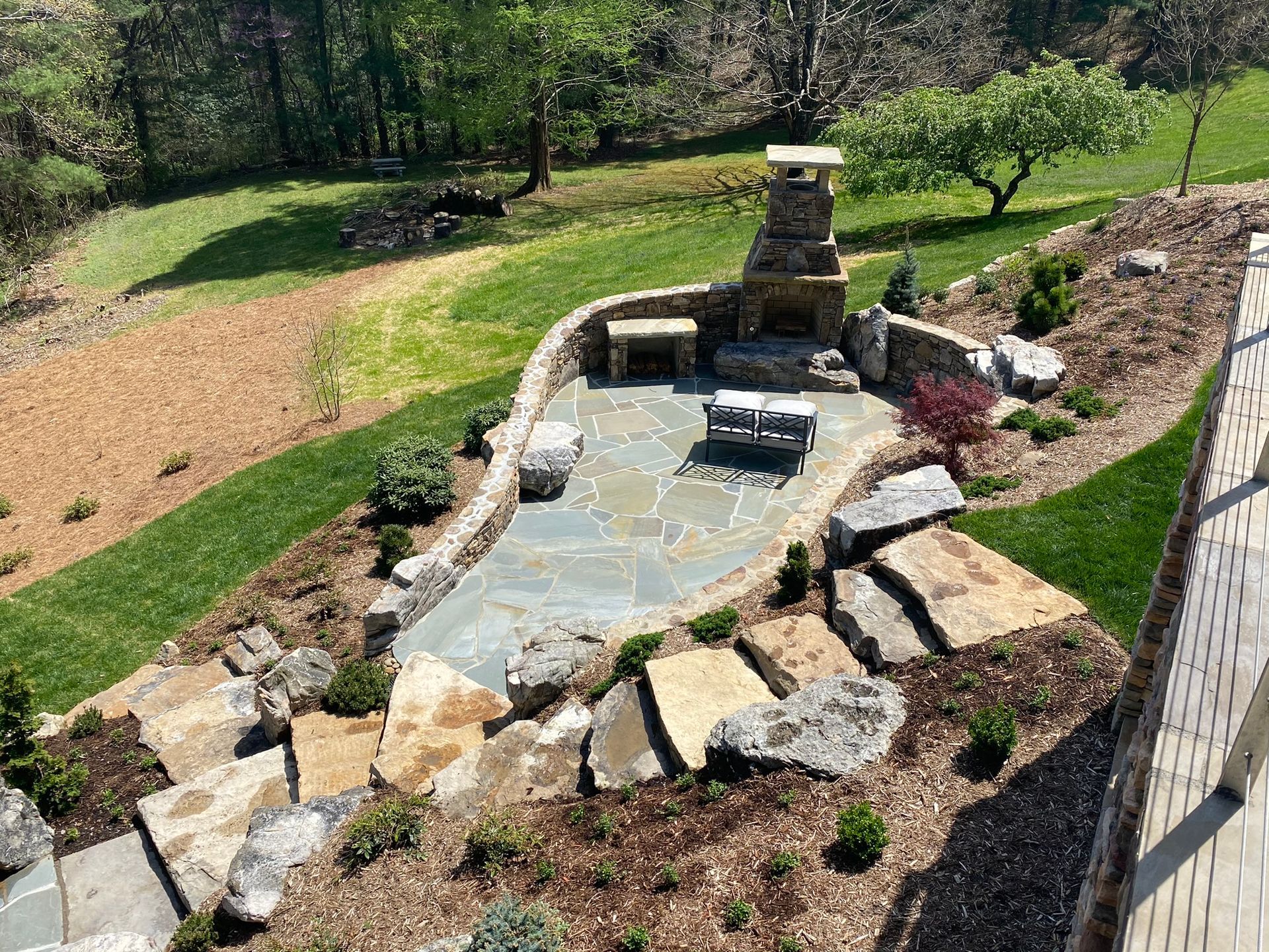 An aerial view of a backyard with a fireplace and patio.